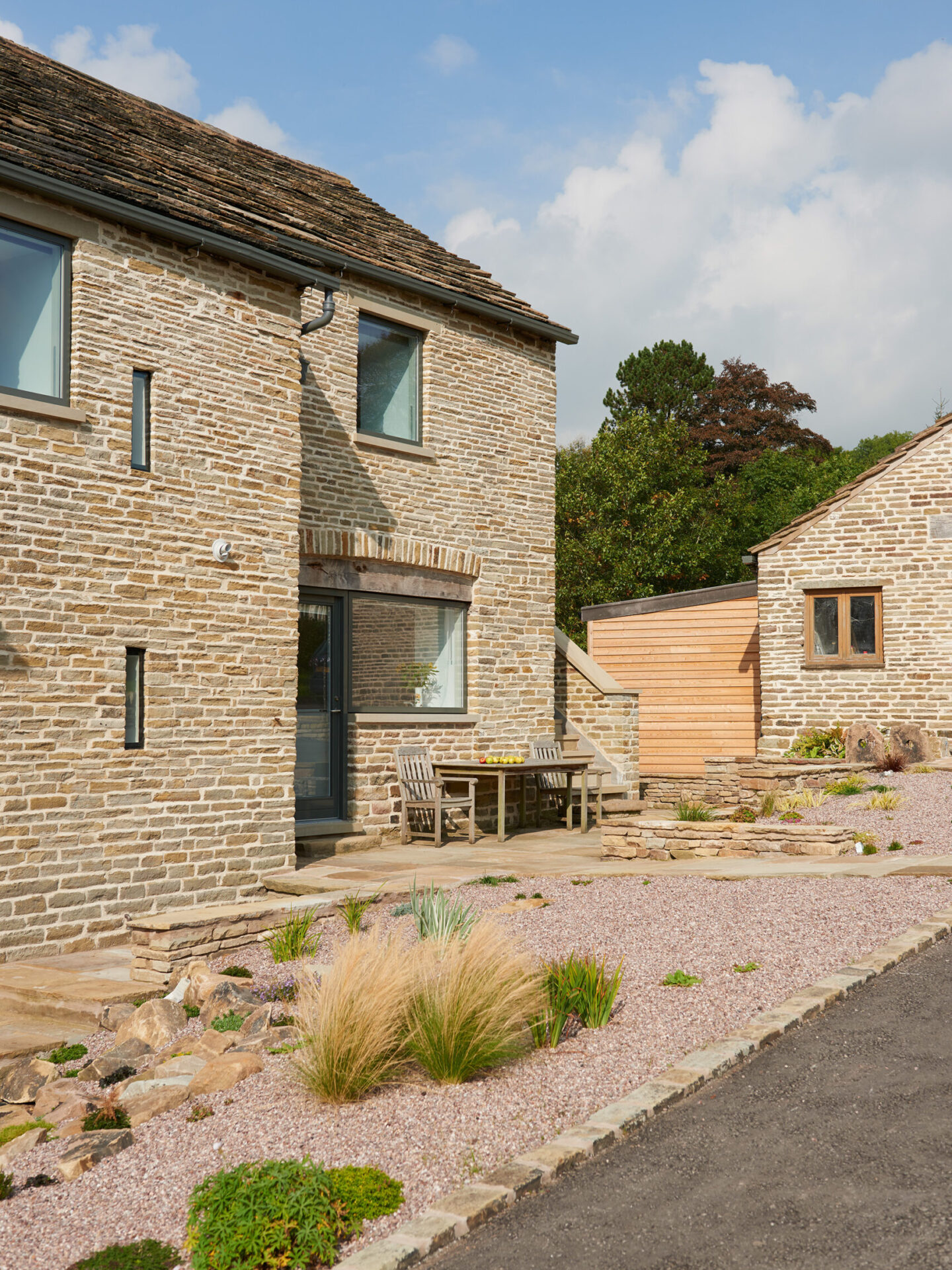 listed stone barn conversion with large glazed openings and outdoor seating area