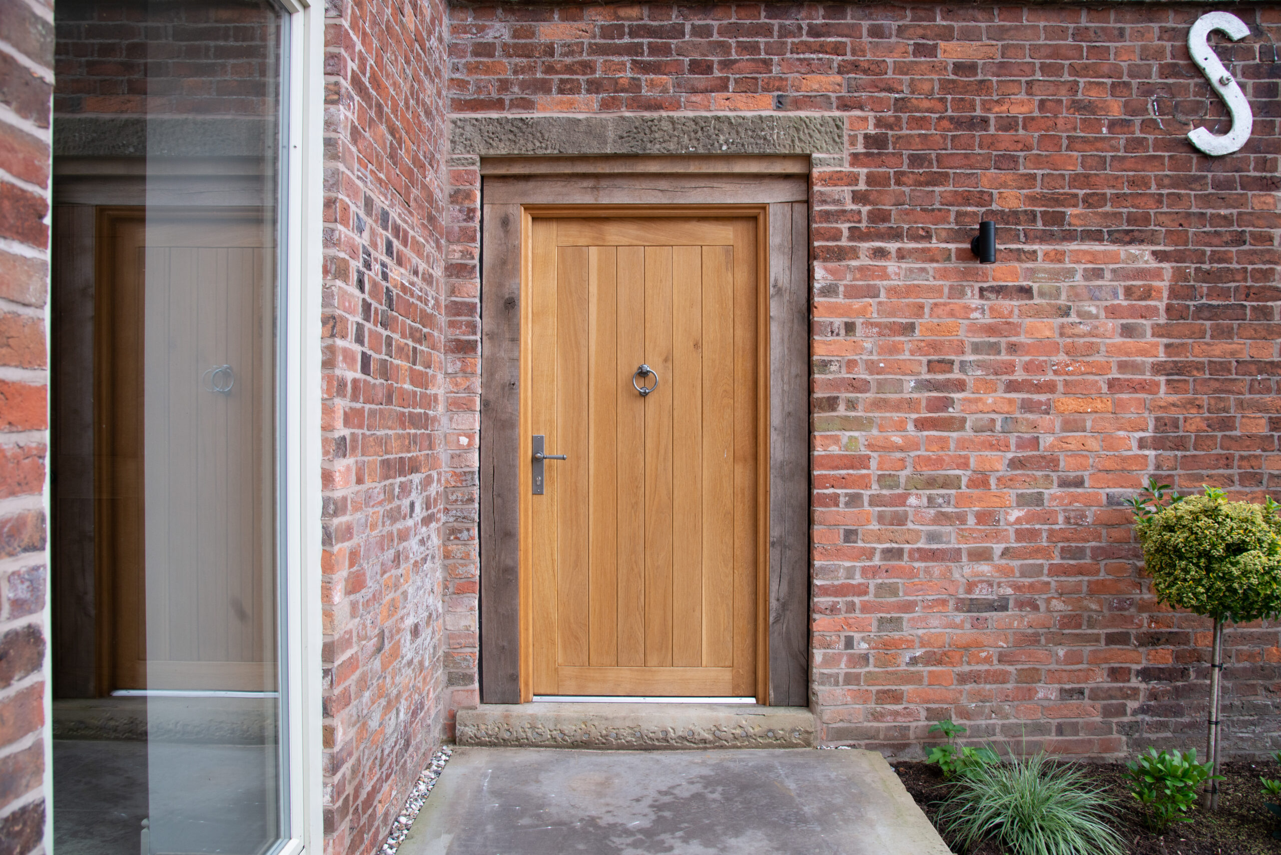 timber entrance door to coach house unit 1 with oak door frame and stone head