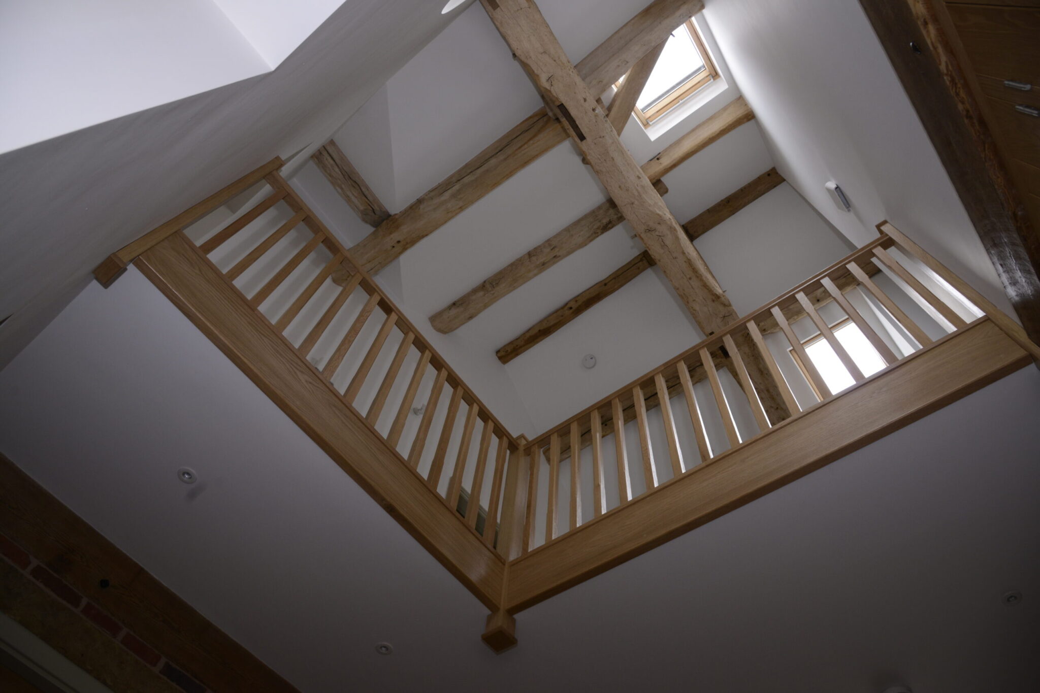 looking up from entrance hall into first floor void with exposed timber frame structure