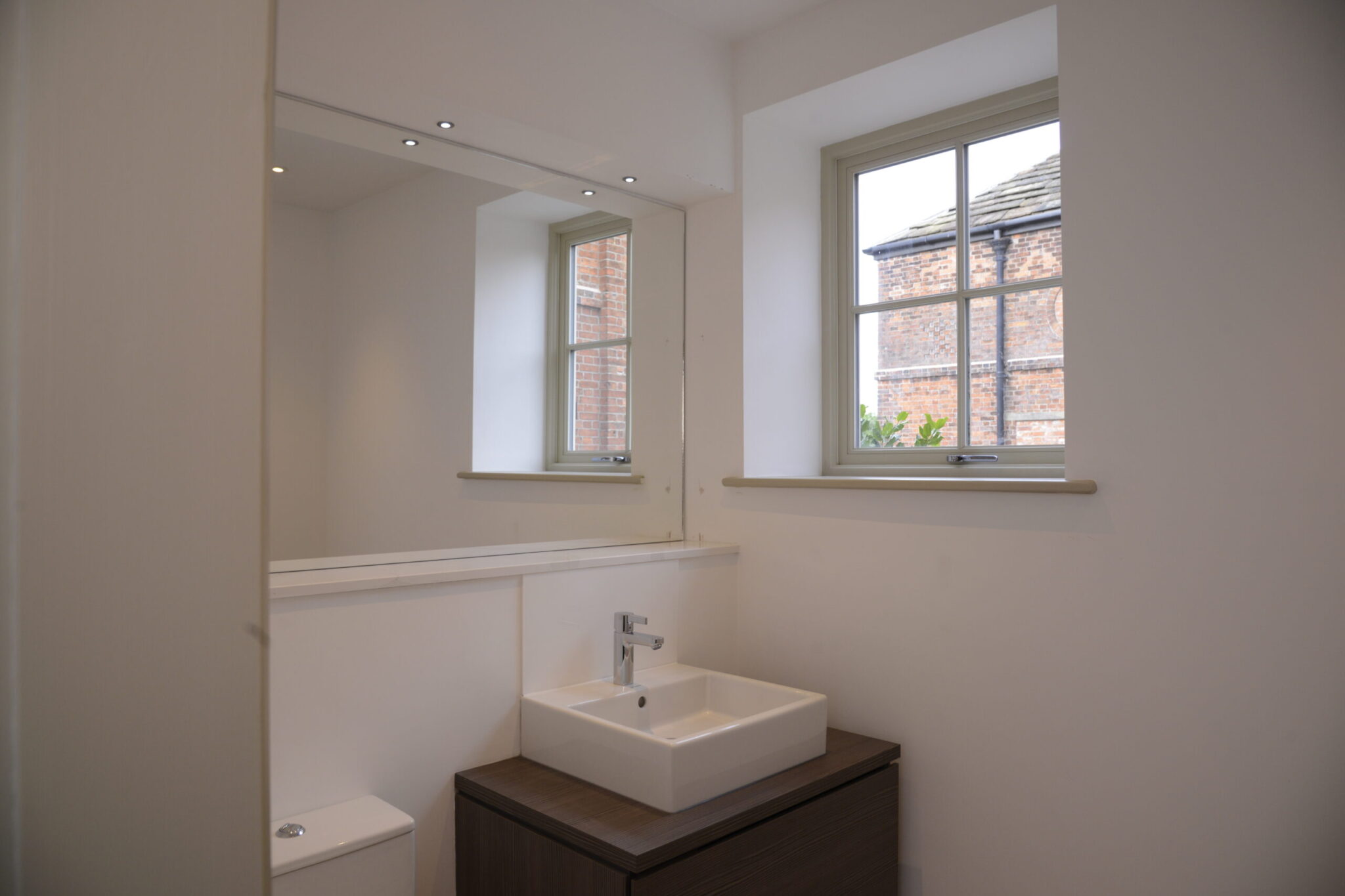 sink, mirror and window of bathroom at coach house unit 1