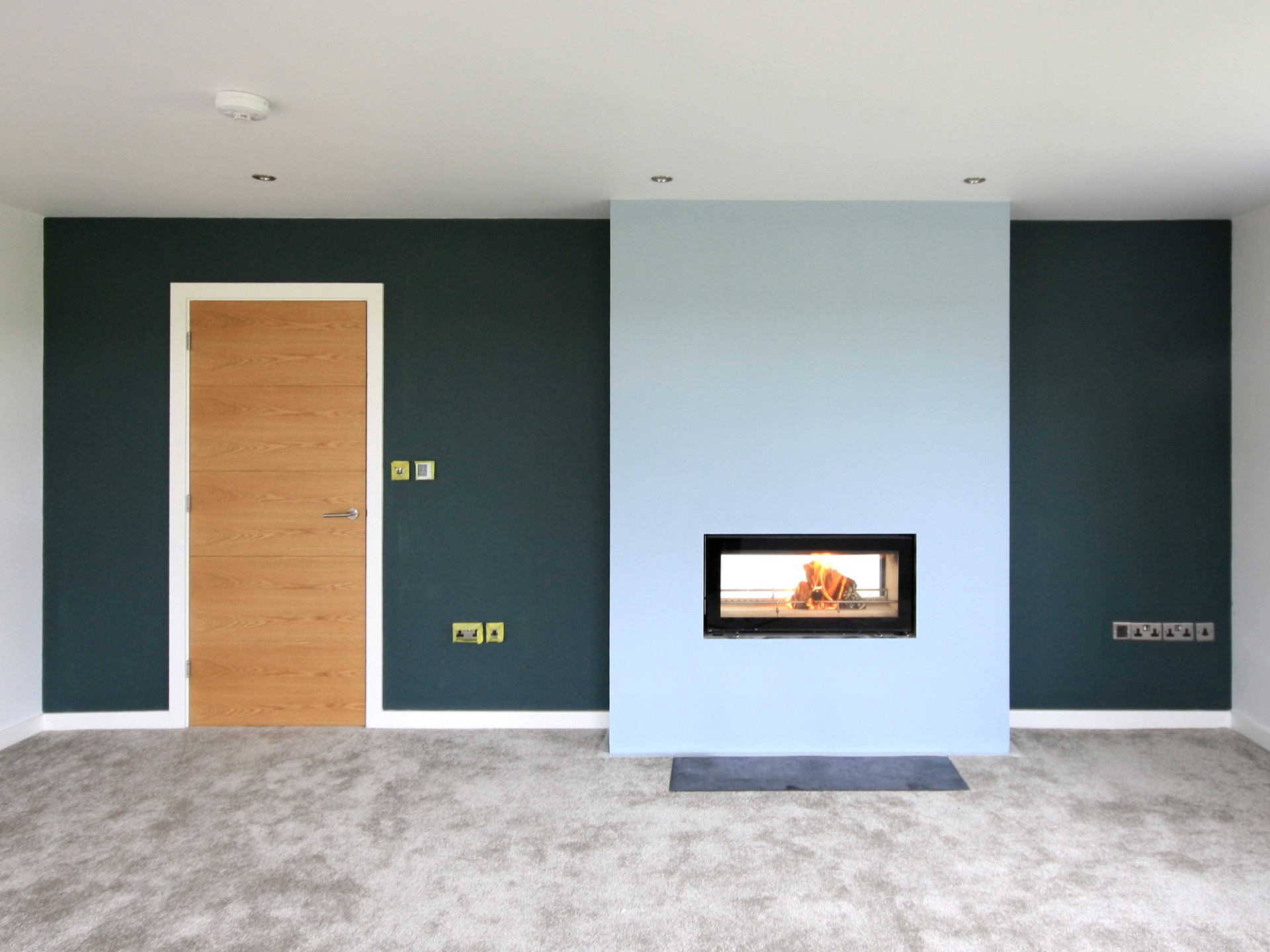 blue feature wall with wood burner built into chimney breast