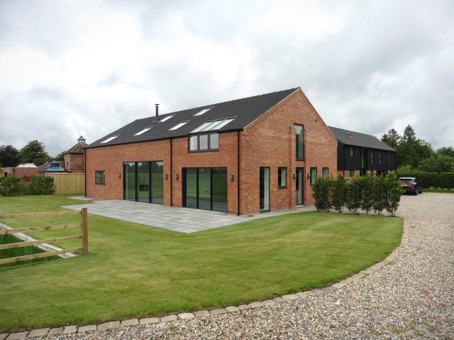 external view at the front corner of bay tree barn, parking area shown and another development at Kermincham Hall Barns