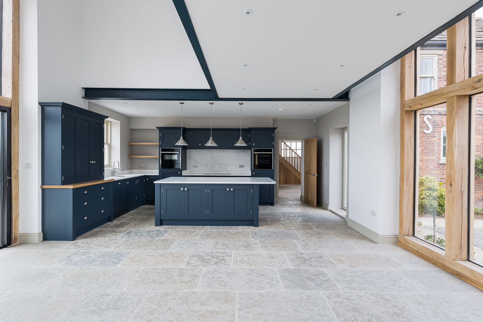 open plan kitchen, dining and living space, with large coach house openings to both sides
