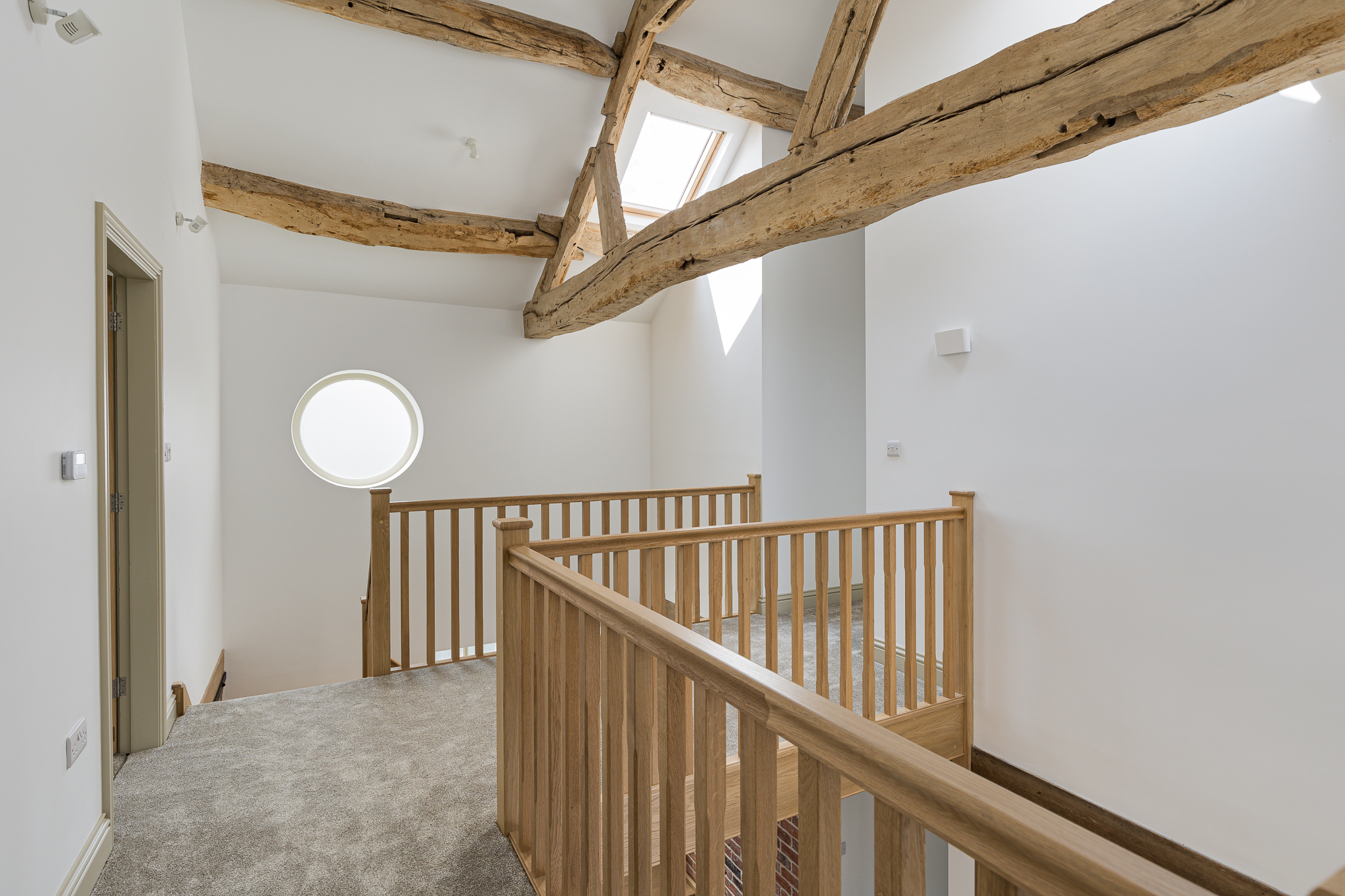 exposed original timber structure with new timber staircase to first floor. original circular window opening and rooflights with natural light