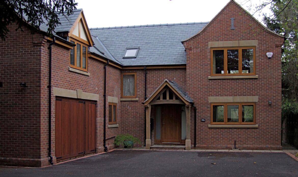 Front entrance and driveway at Byrons Lane with oak porch and oak frame glazing with stone details