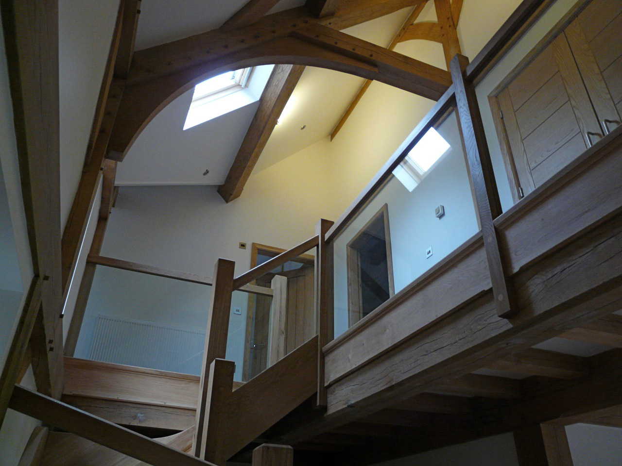 staircase and exposed timber roof structure at Byrons Lane with glass balustrade
