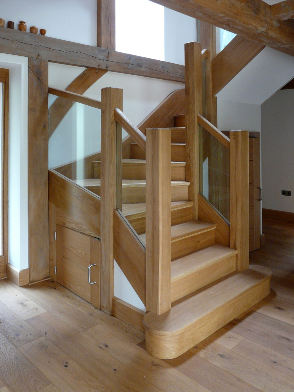 timber staircase with glass balustrade and timber flooring