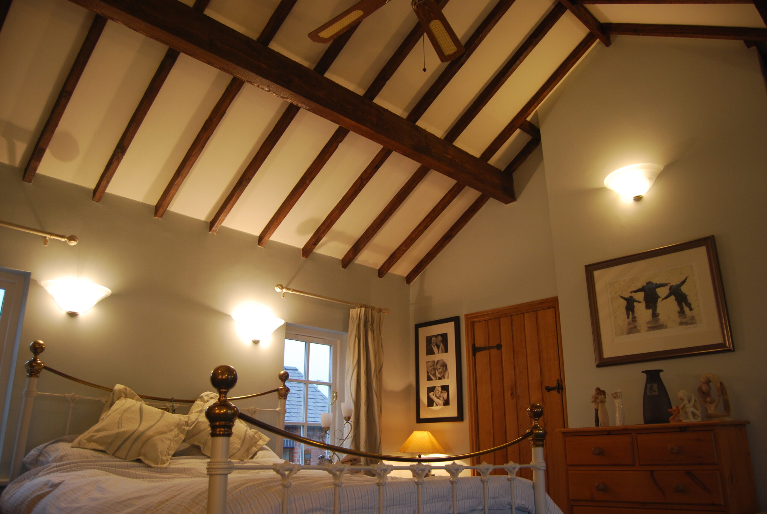 bedroom with exposed timber roof structure with plastered infill