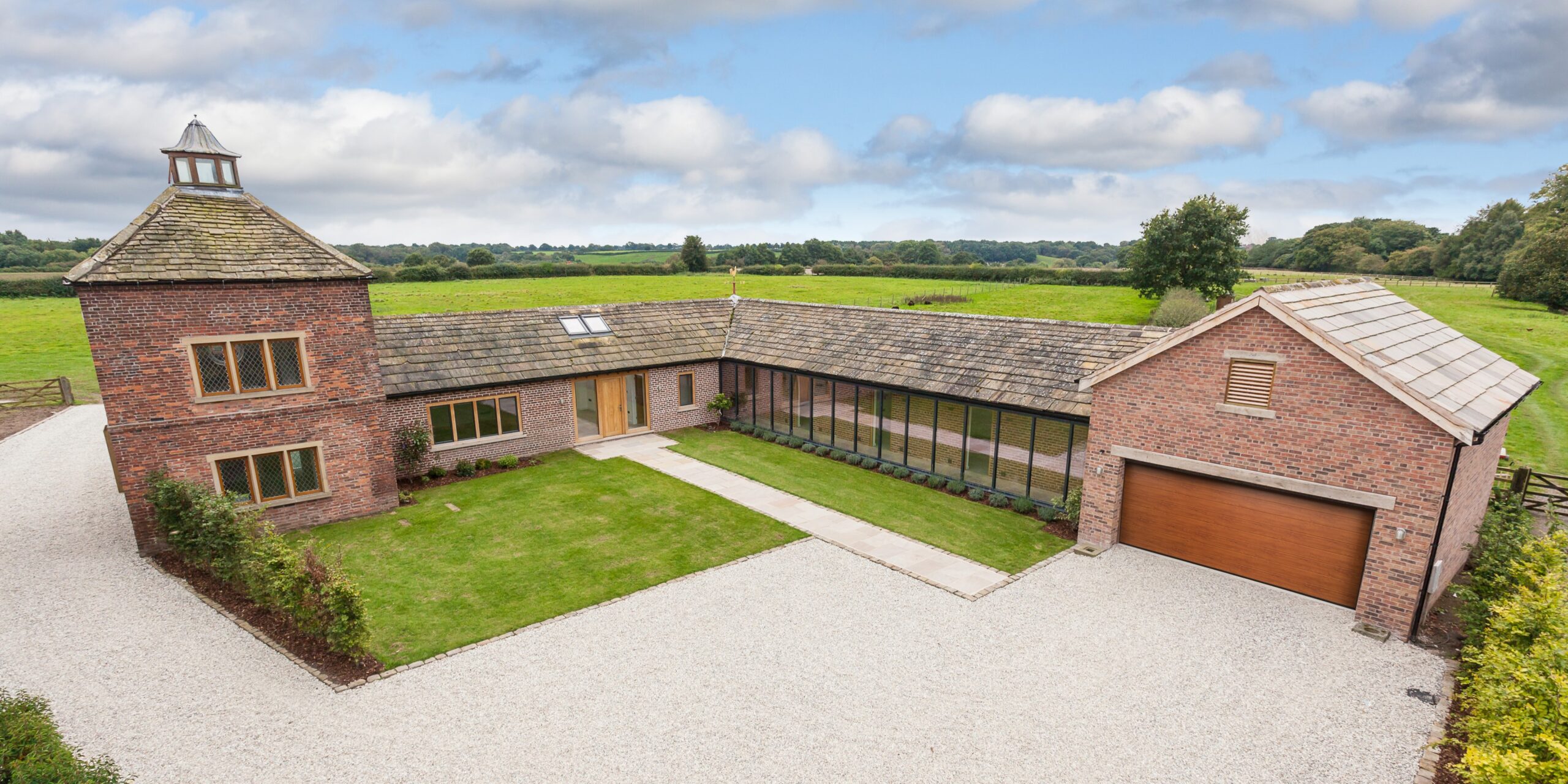 elevated view of converted pigeon house and stables with extensions and glazed corridor to a dwelling