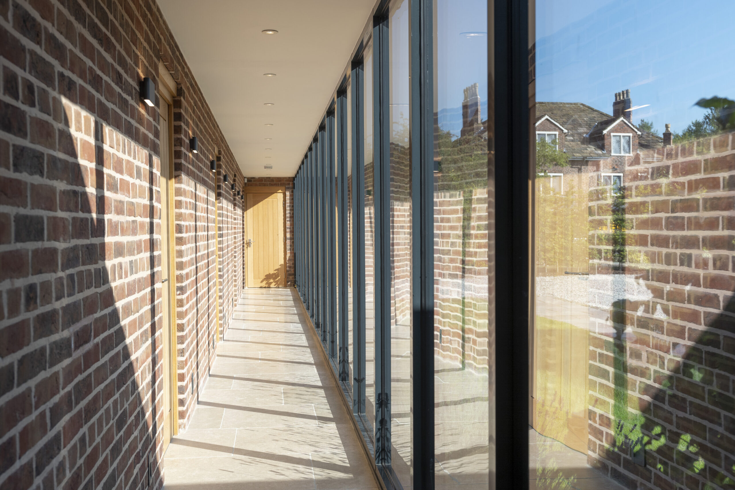 glazed corridor providing access to bedrooms with natural light entering
