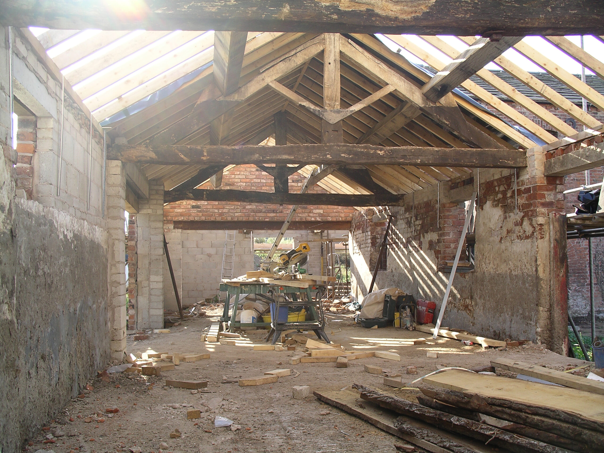 derelict barn with exposed timber trusses and brick walls