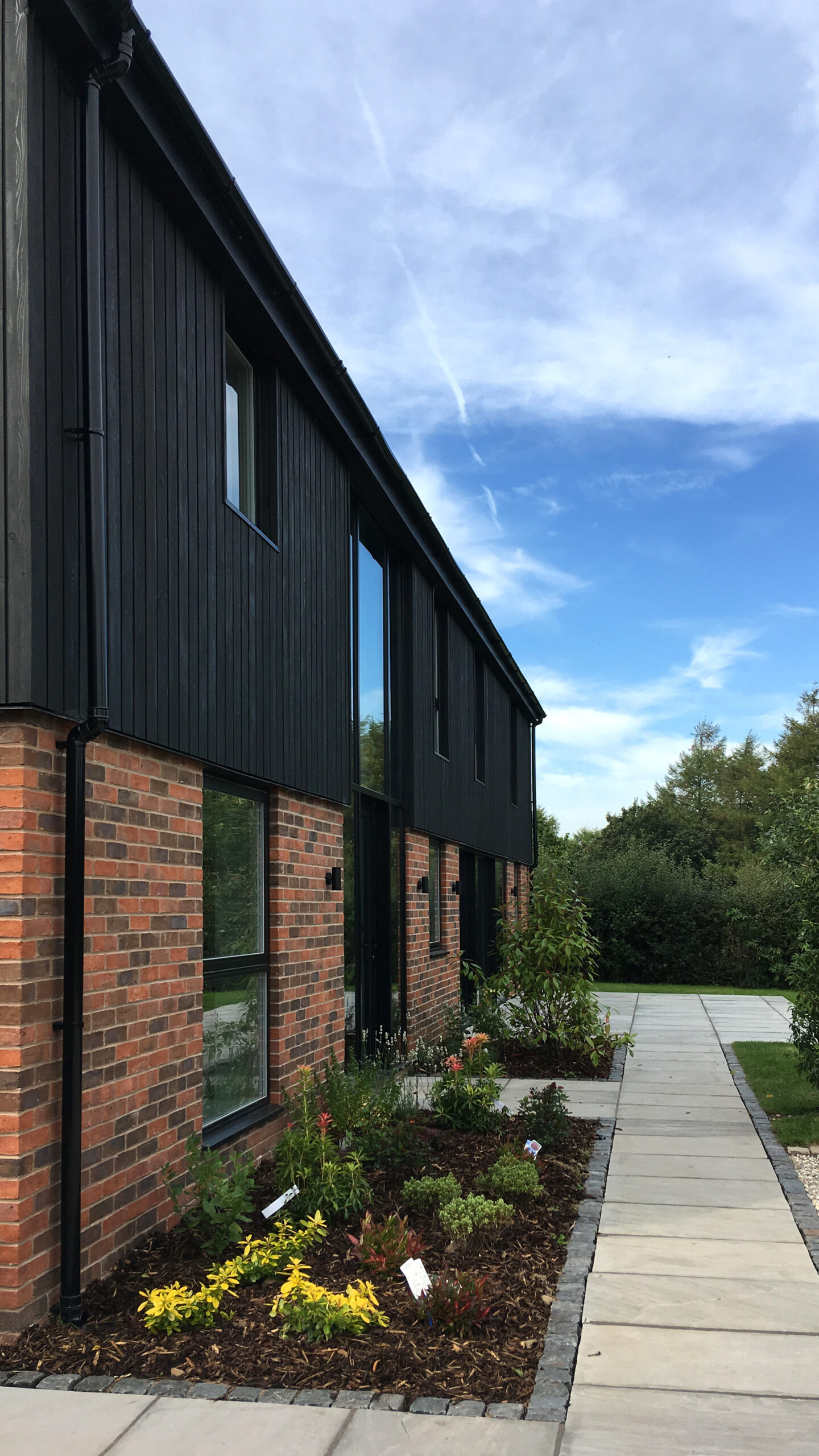 brick replacement dwelling with black timber cladding at first floor