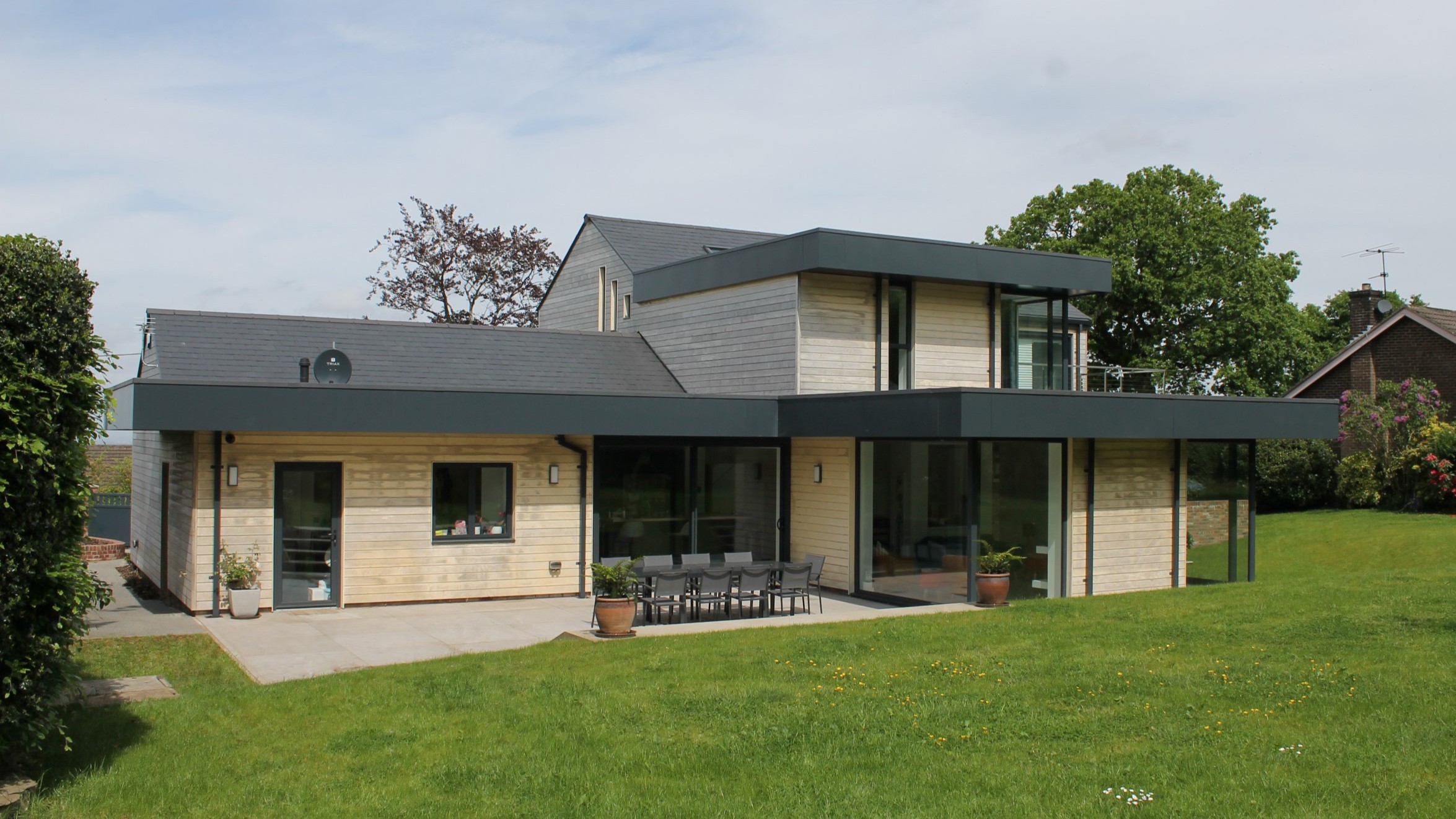 contemporary rear elevation with timber cladding and metal overhanging roof