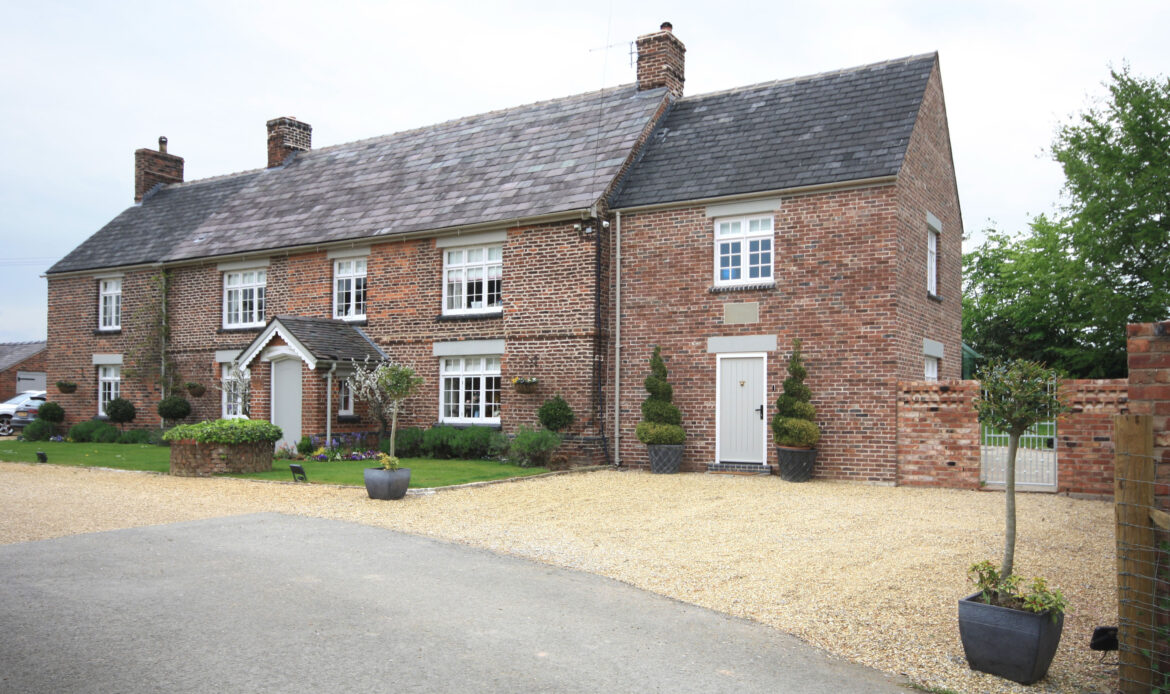 front elevation of Swanwick Hall with gravel driveway and two storey side extension with access gate to rear garden