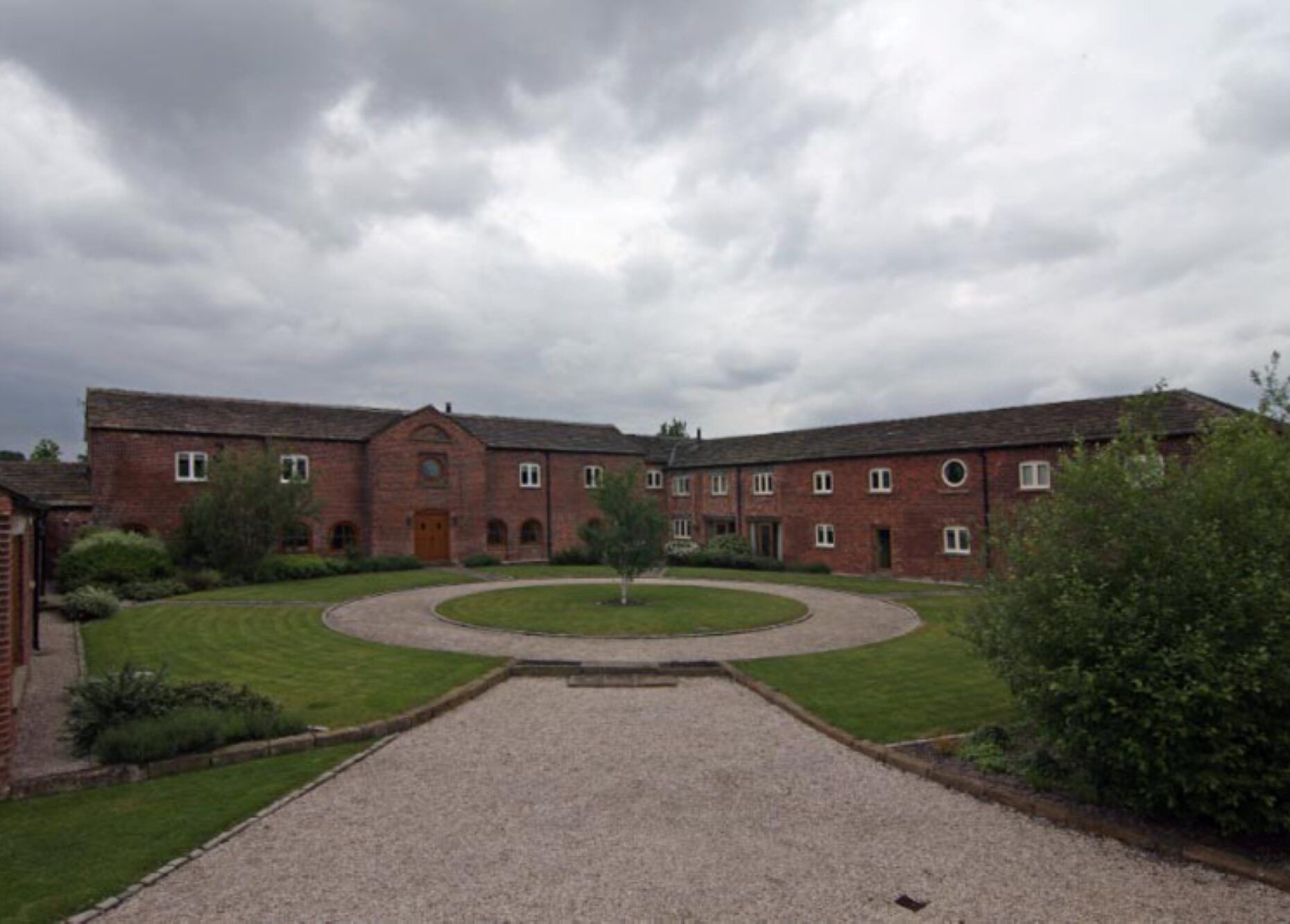 converted brick barns with courtyard with circular gravel path