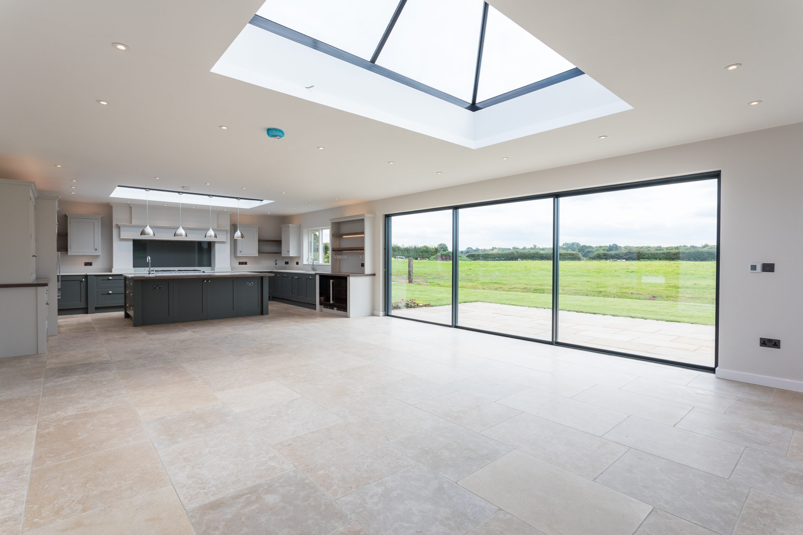 open plan kitchen, dining and living space with roof lantern in the next single storey extension with sliding doors opening onto the rear garden patio