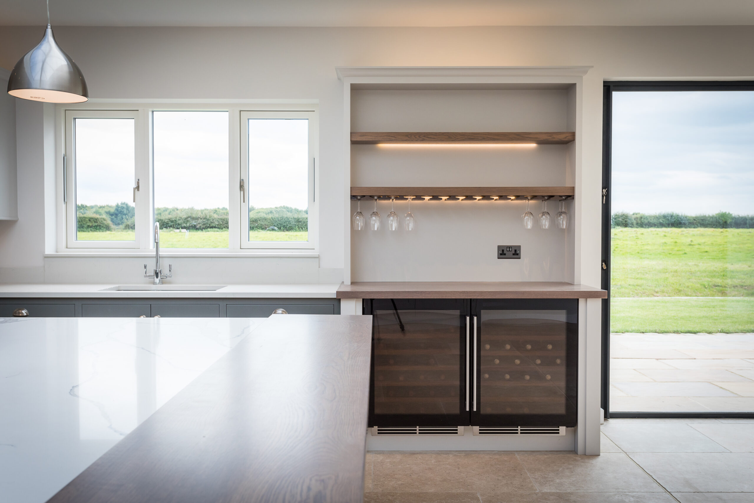 modern kitchen with built in bar with views out onto the rear garden and surrounding countryside