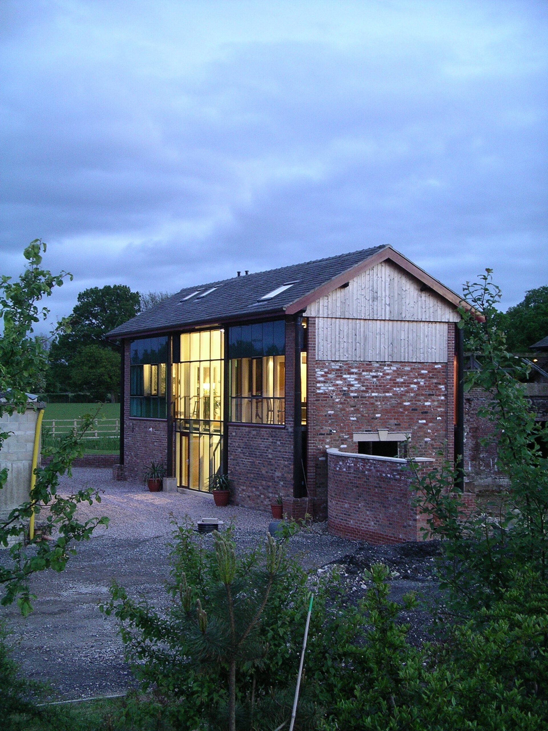 light spilling from large glazed openings at Beech Farm barn conversion