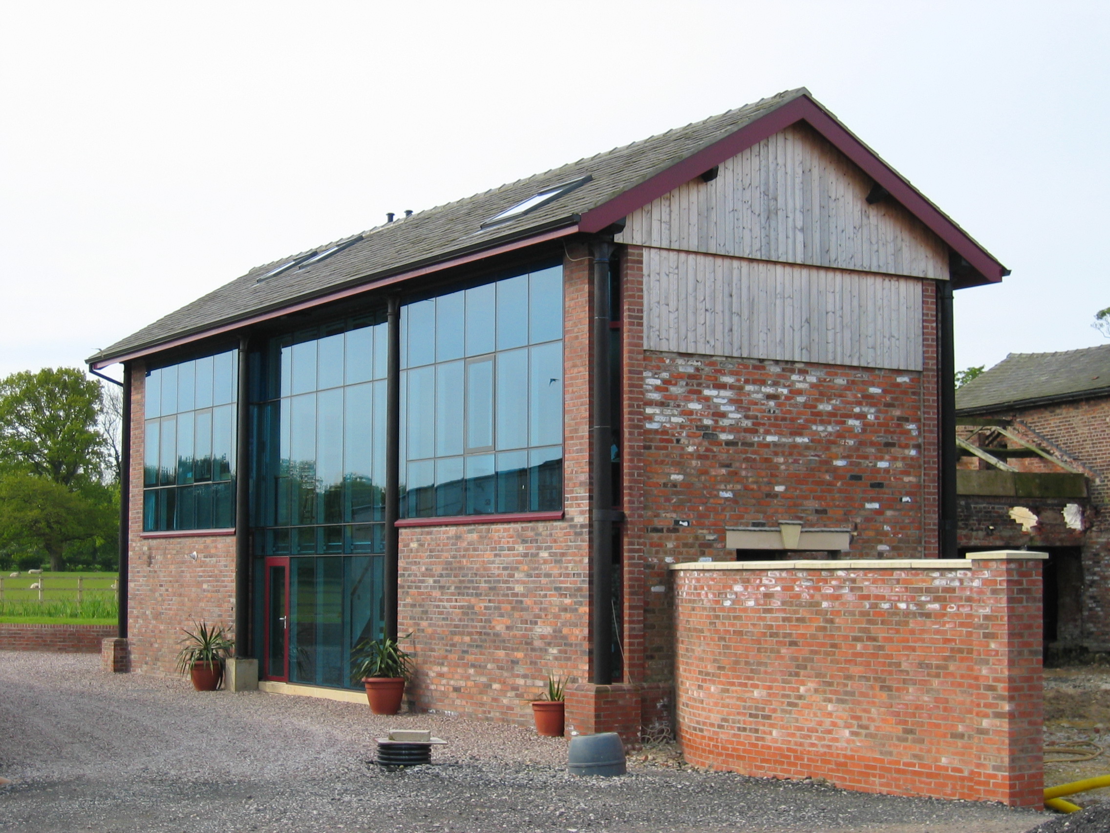 brick barn conversion with timber cladding, large glazed openings and steel columns