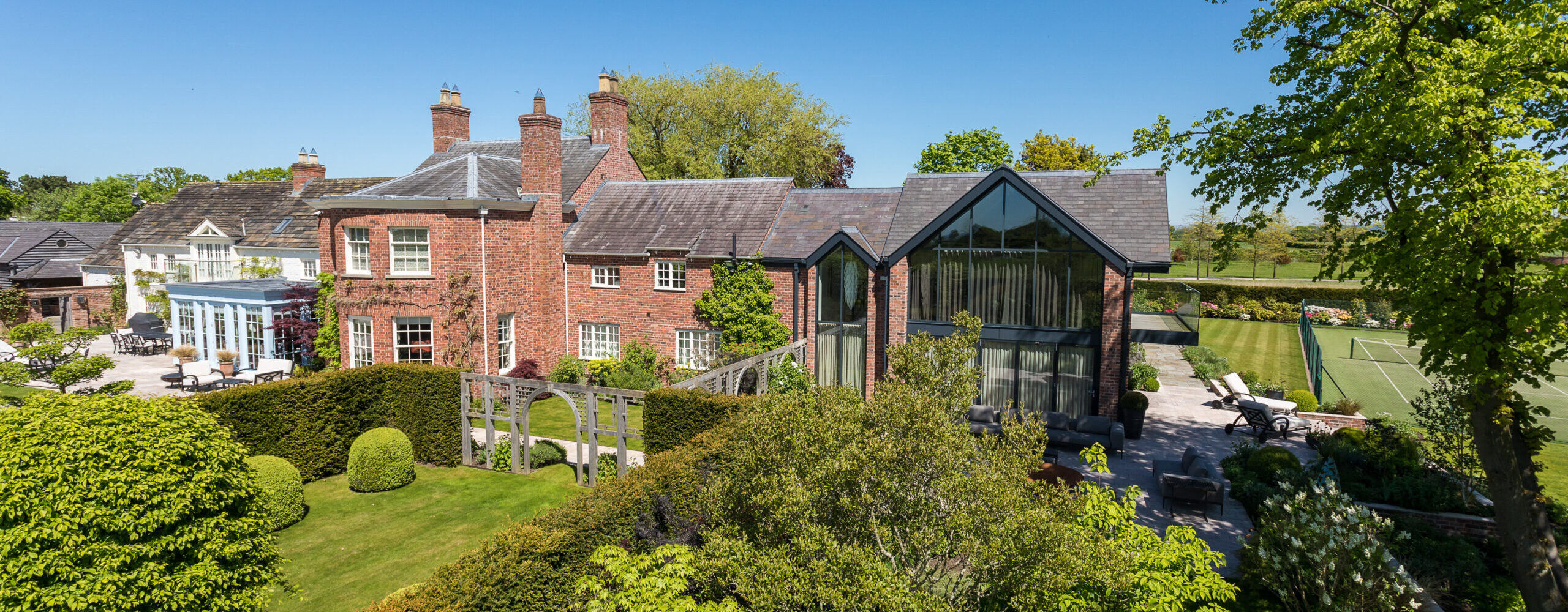 elevated view at Ash House of dwelling, extensions, surrounding grounds and tennis court