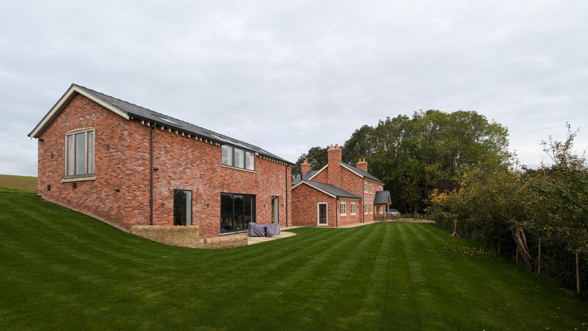external view of ancillary building and dwellinghouse with the site level rising at the rear