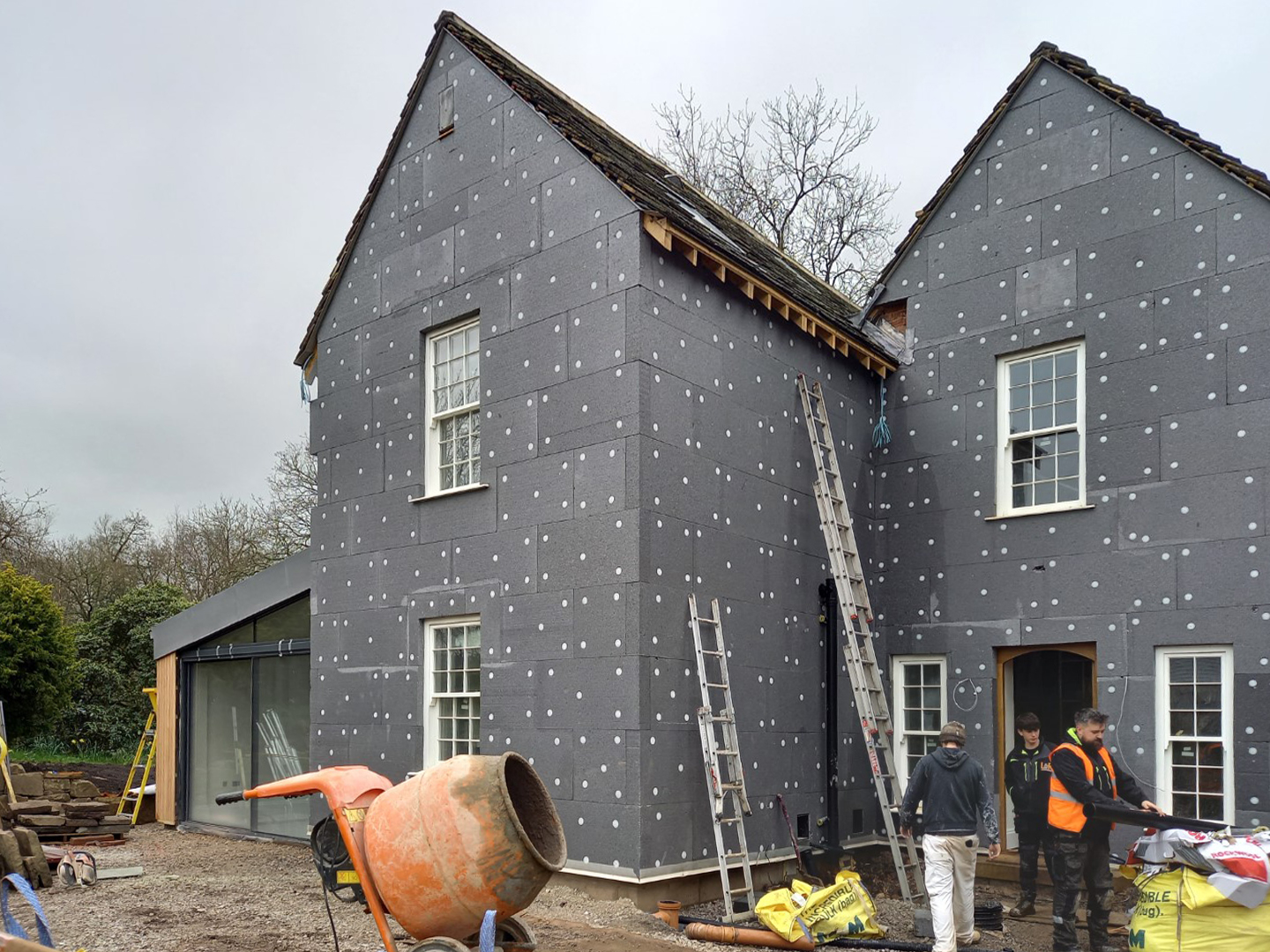 External wall insulation being fitted to an existing building as part of extensions and renovations to improve the buildings thermal performance