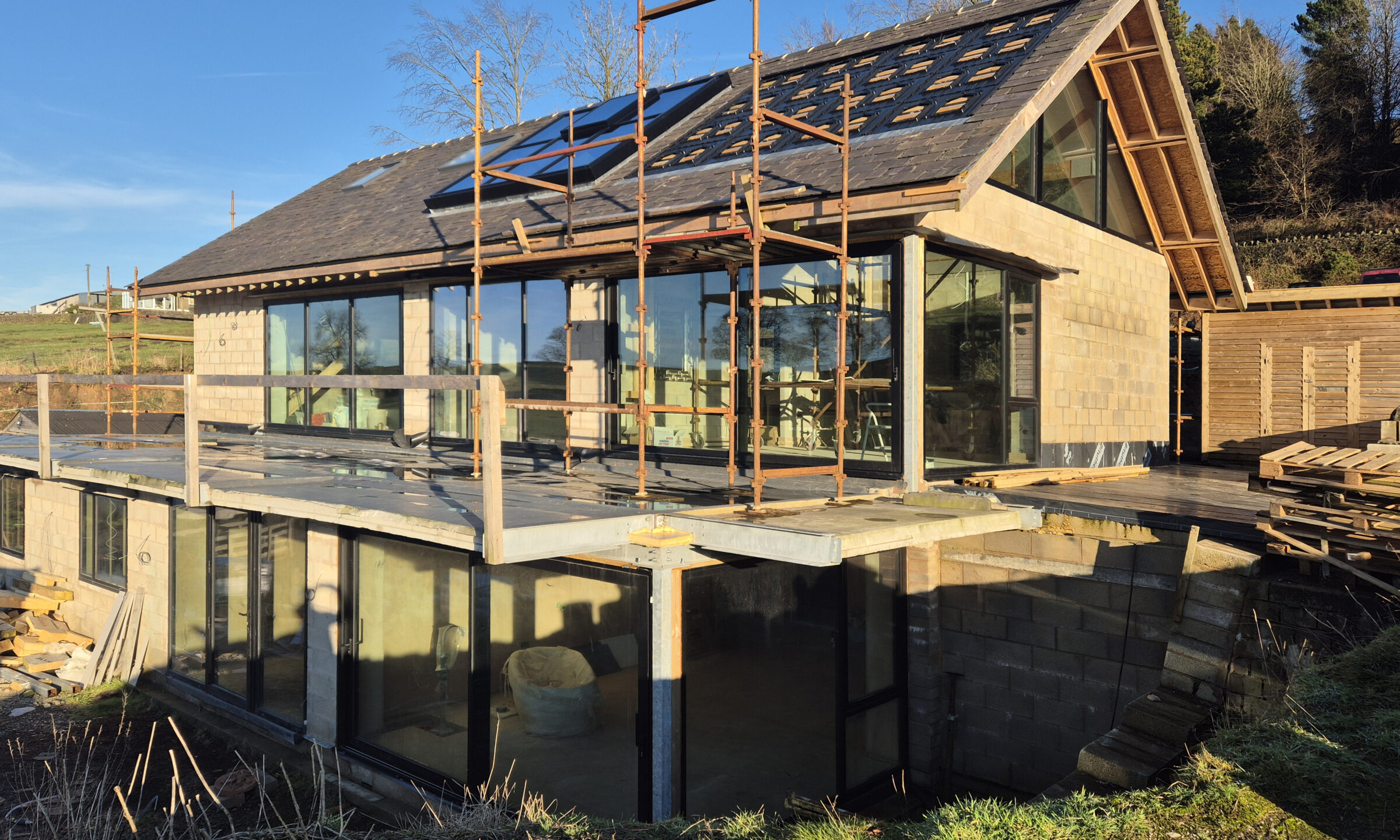 replacement dwelling under construction with inset solar panels and large glazed areas throughout