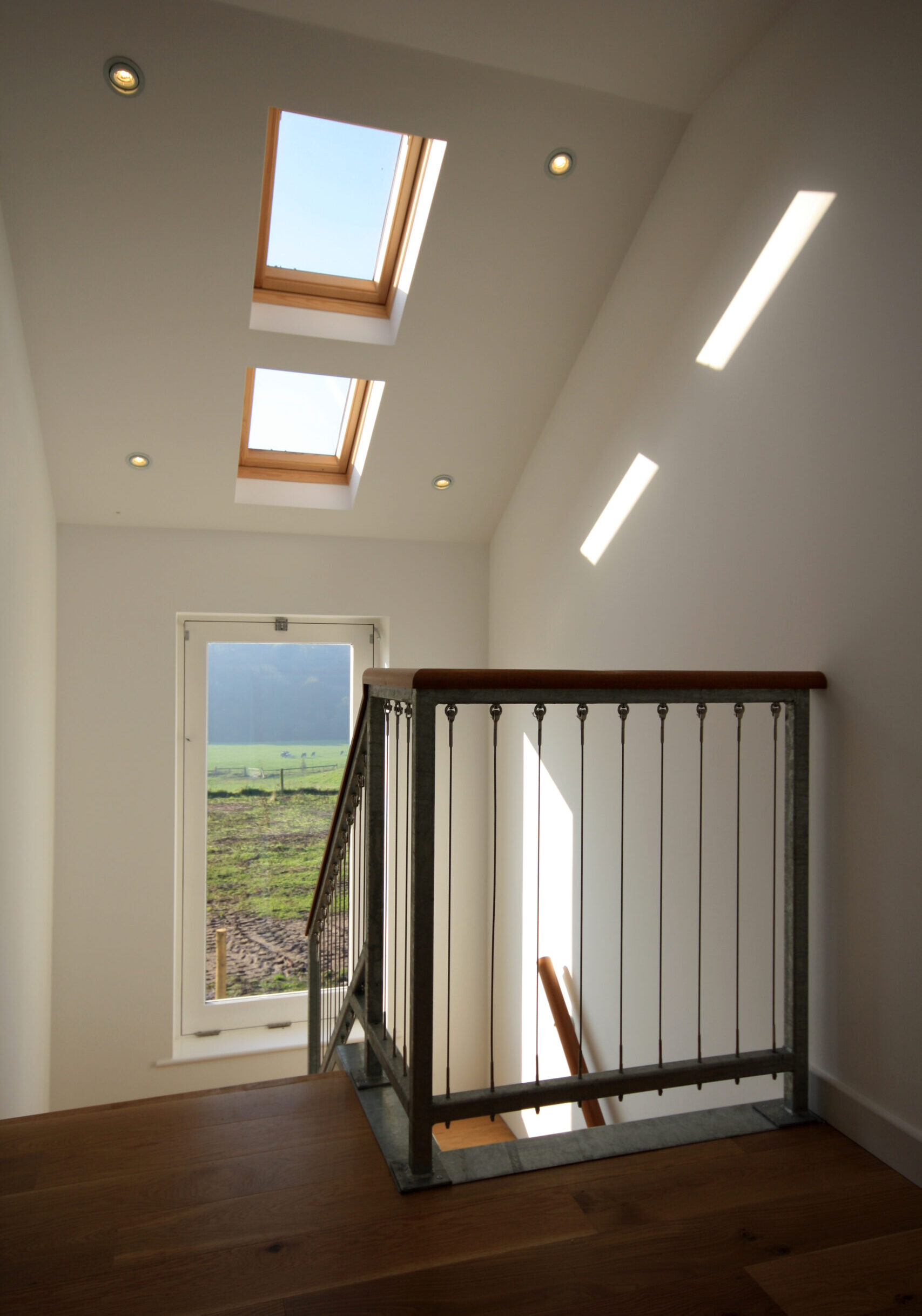 first floor landing with steel balustrade with timber railing and rooflghts and large landing window