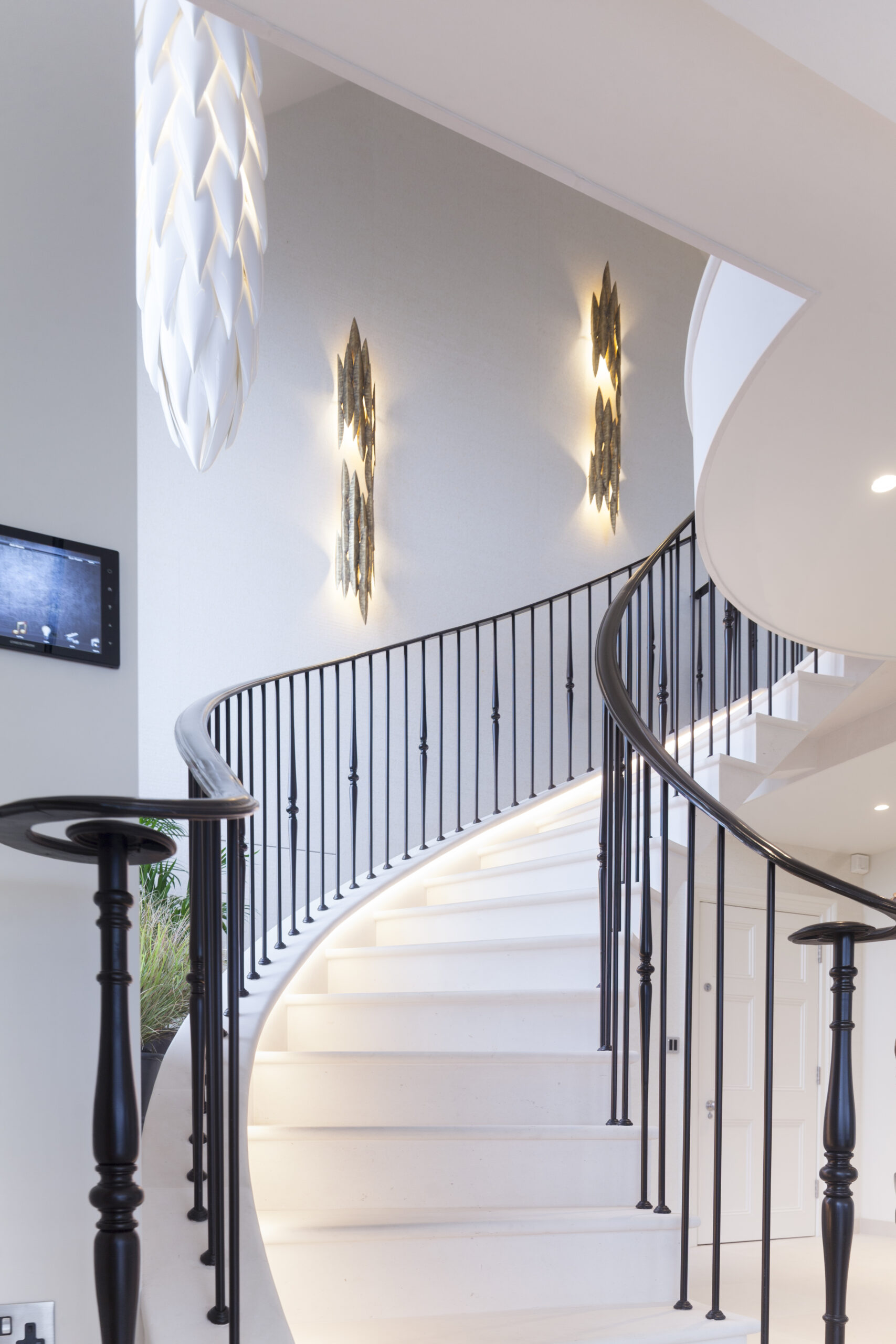 solid stone staircase up to games room with feature artwork and lighting