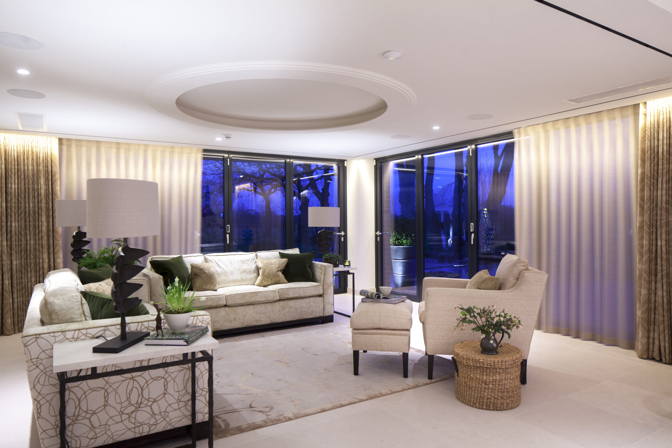evening interior view of sitting room with coffered ceiling feature and large glazing