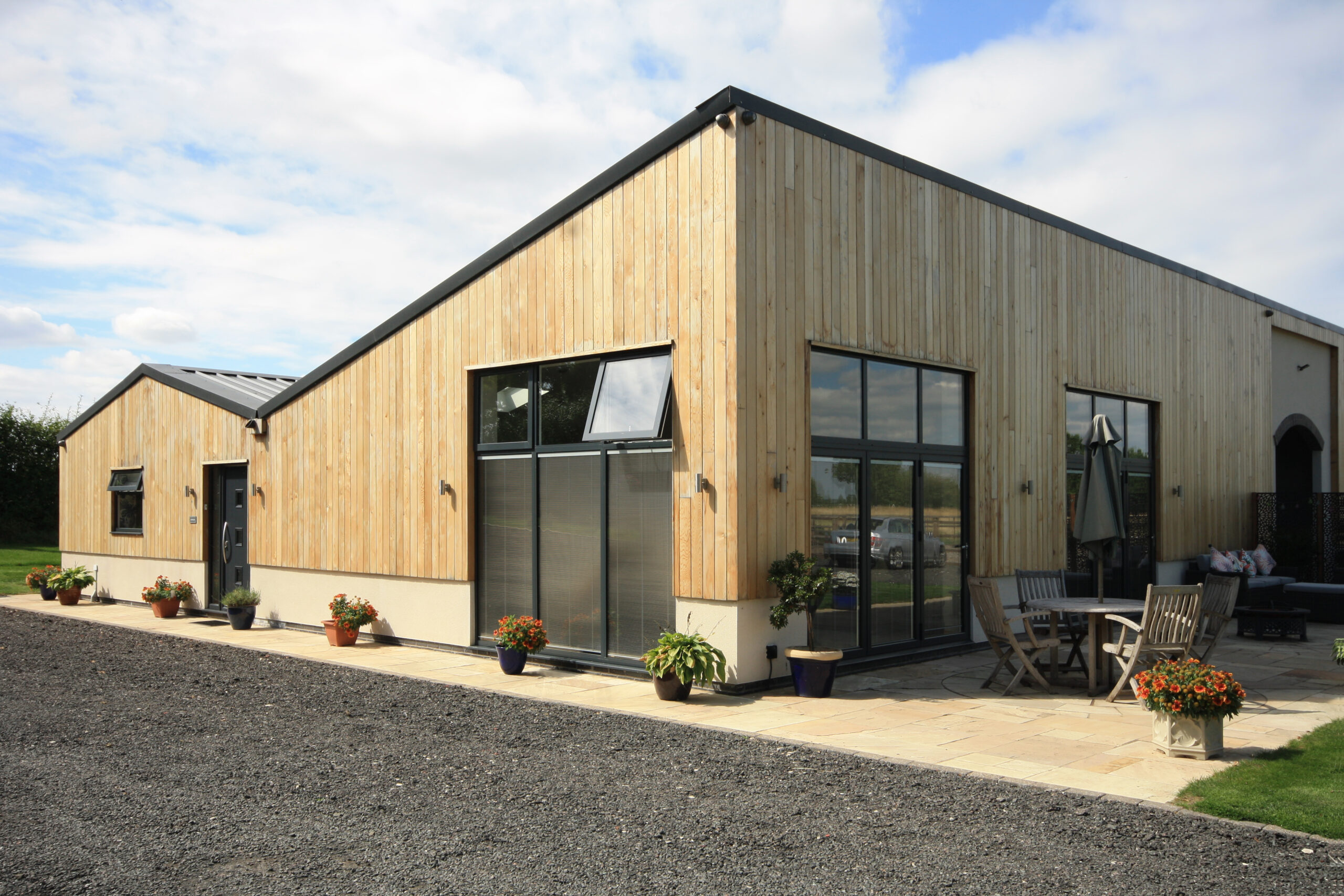 vertical timber cladding with plaster finish at low level to partial conversion. Large glazed openings offering views of large gardens and horse fields