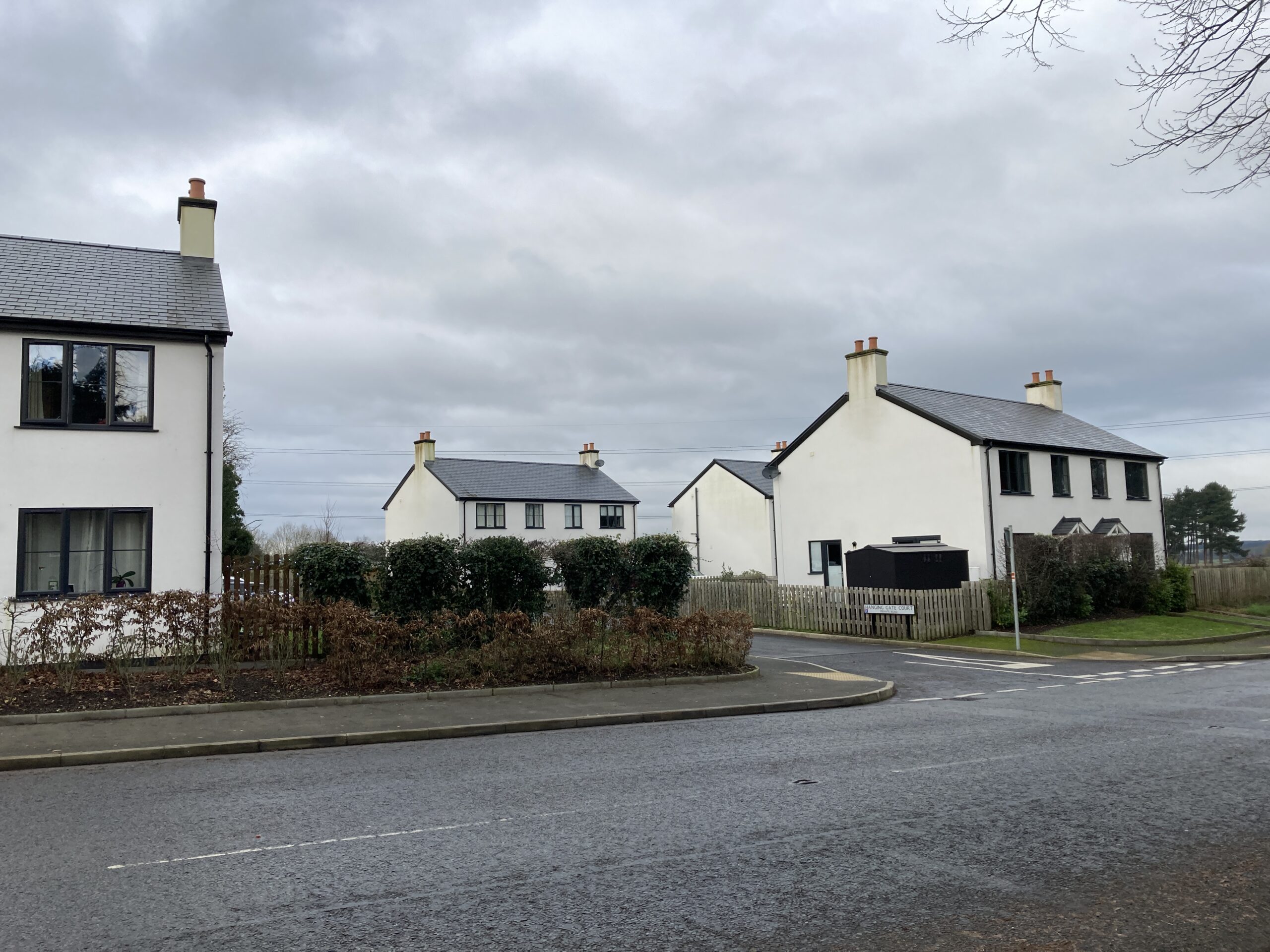 Hanging Gate Court entrance road entering the affordable dwellings development at Hanging Gate Court and a view of the dwellings fronting onto the street