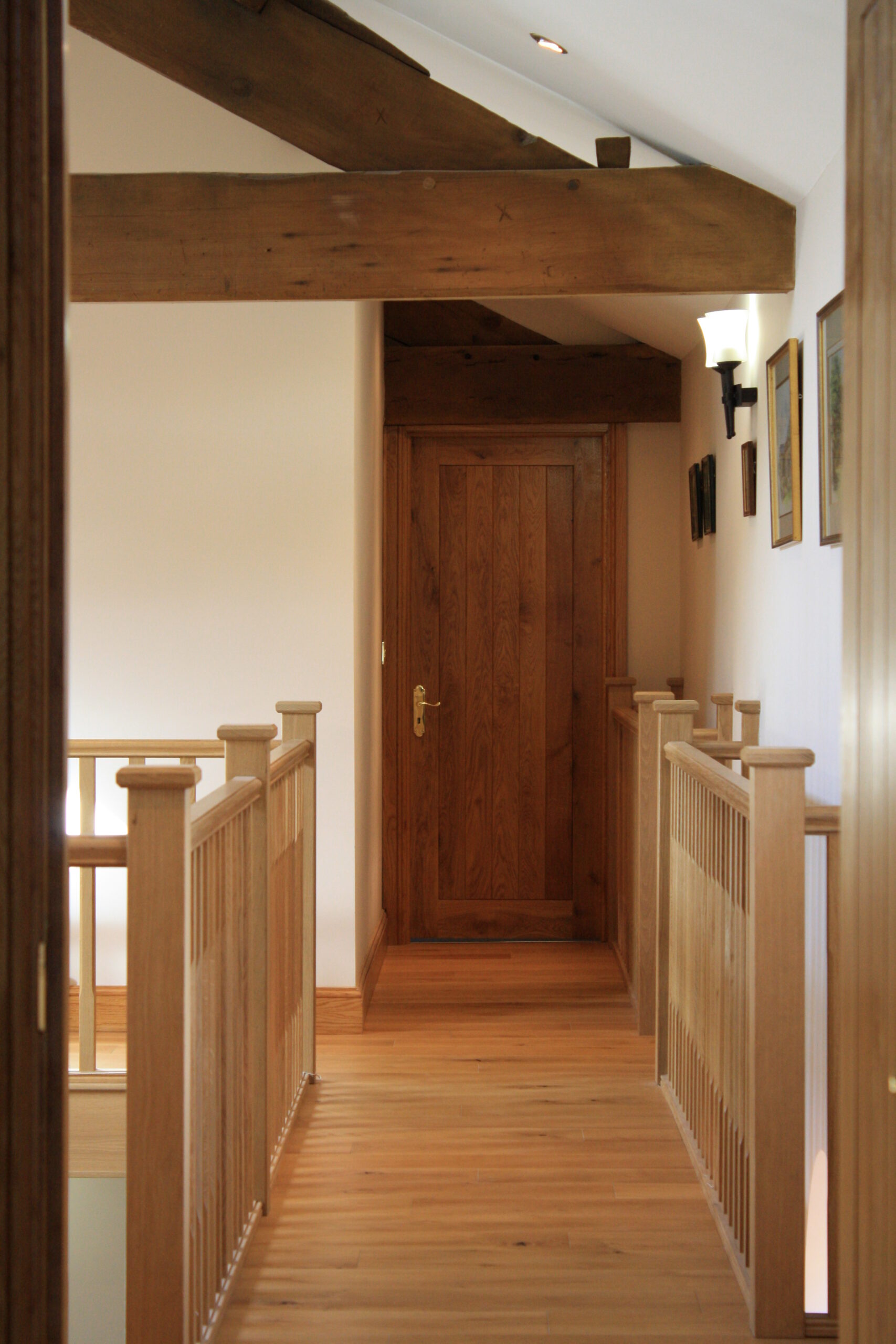 view across the galleried landing towards bedroom doors with raked ceilings