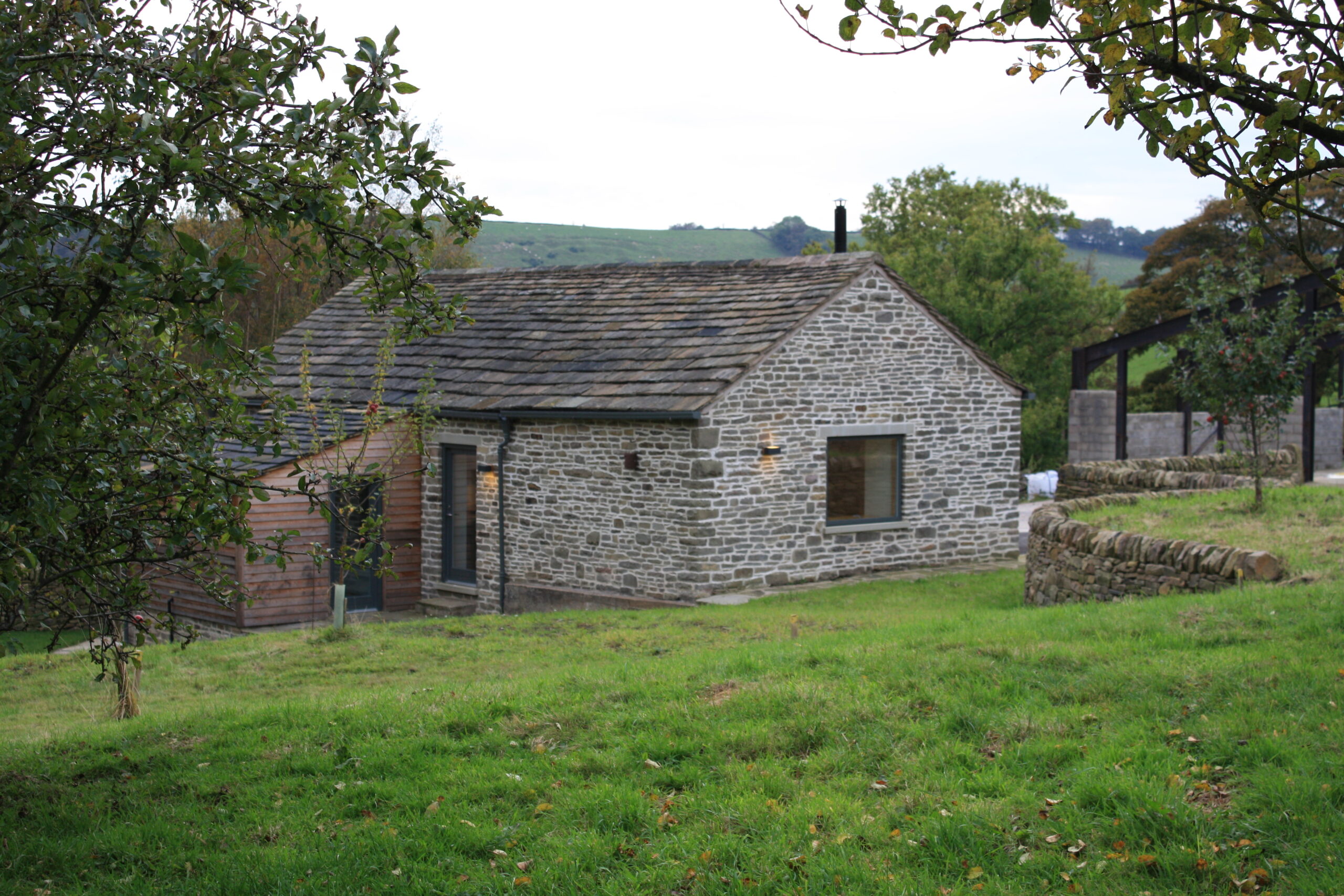 converted stone barn in garden with views of surrounding countryside