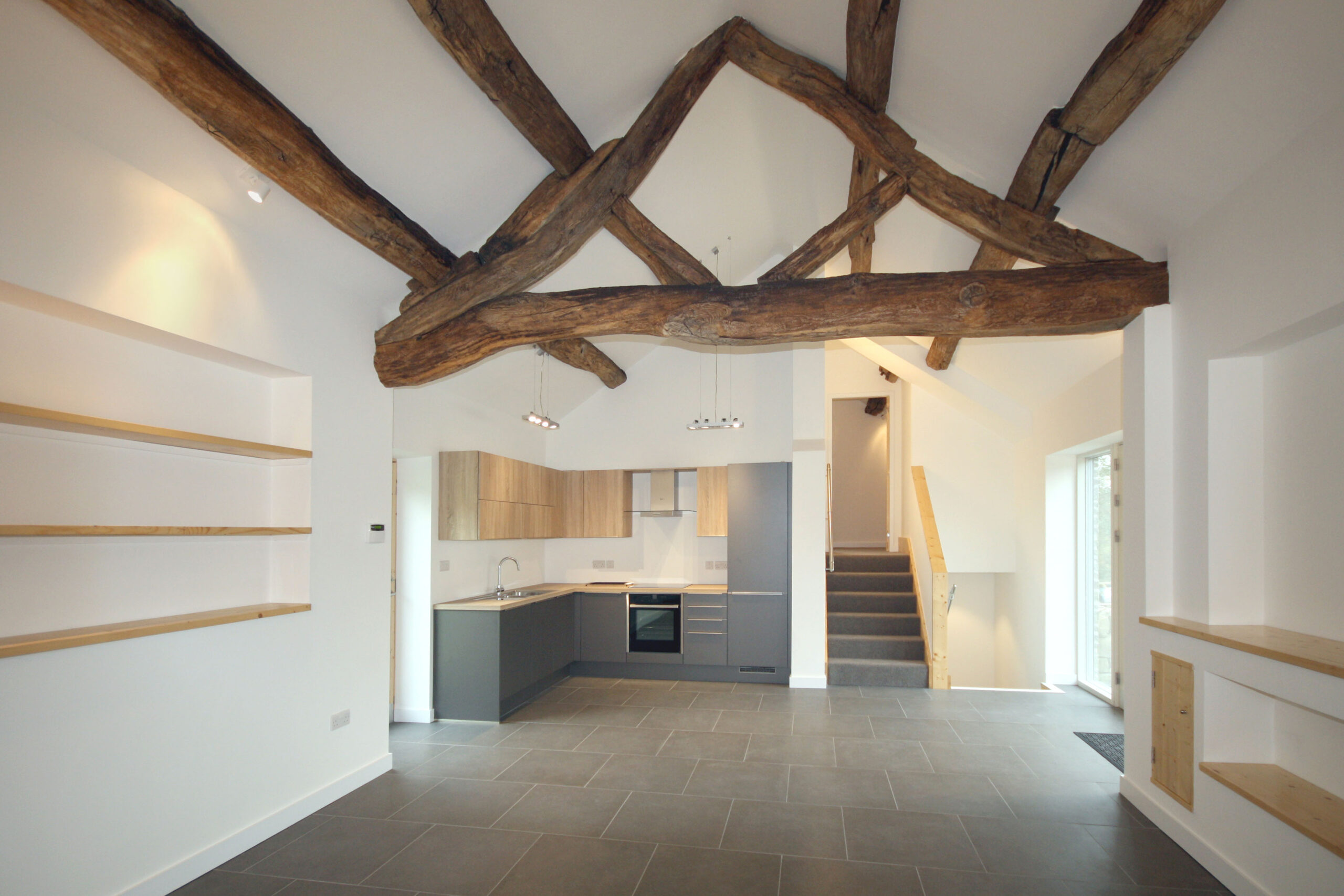 kitchen in barn conversion with exposed retained timber roof truss
