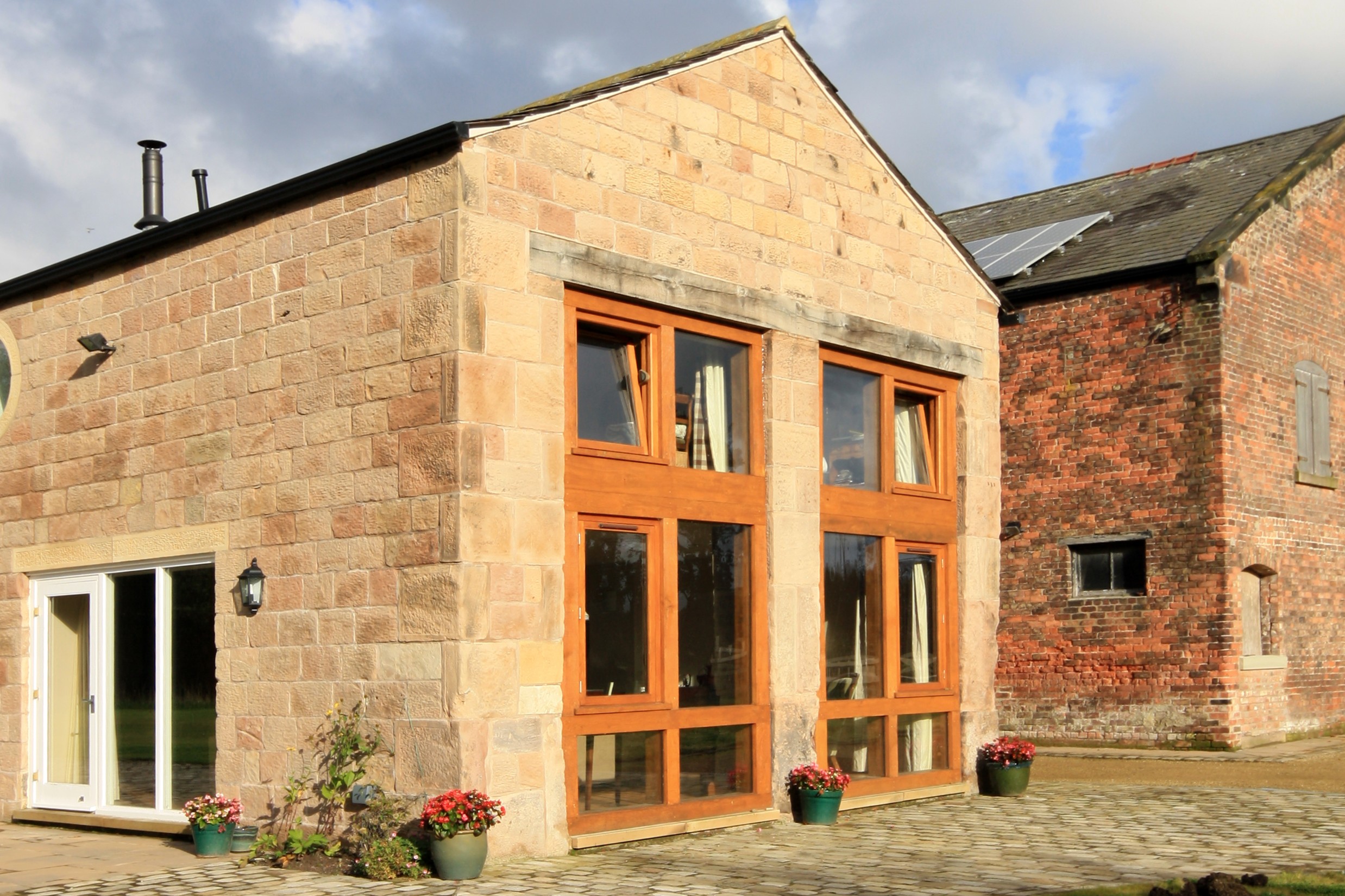 converted stable block at Moor Hall Farm with large opening retained with oak framed glazing