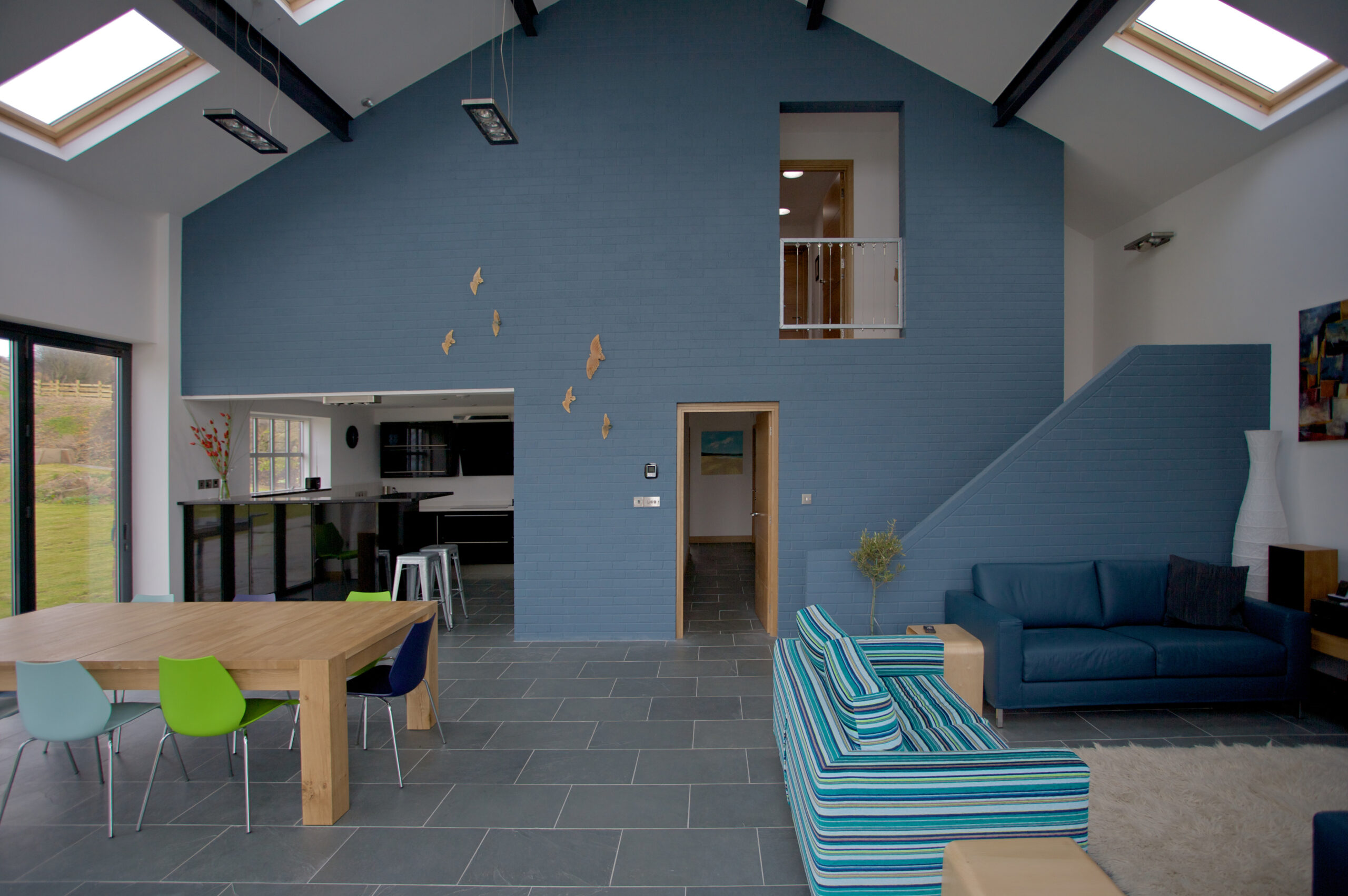 double height open plan living space withe exposed paint brick and exposed steel roof structure