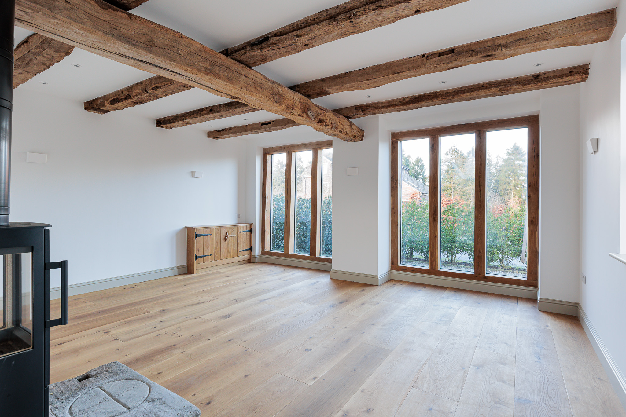 sitting room at Coach House Unit 2 with exposed timber floor joists and oak framed glazing