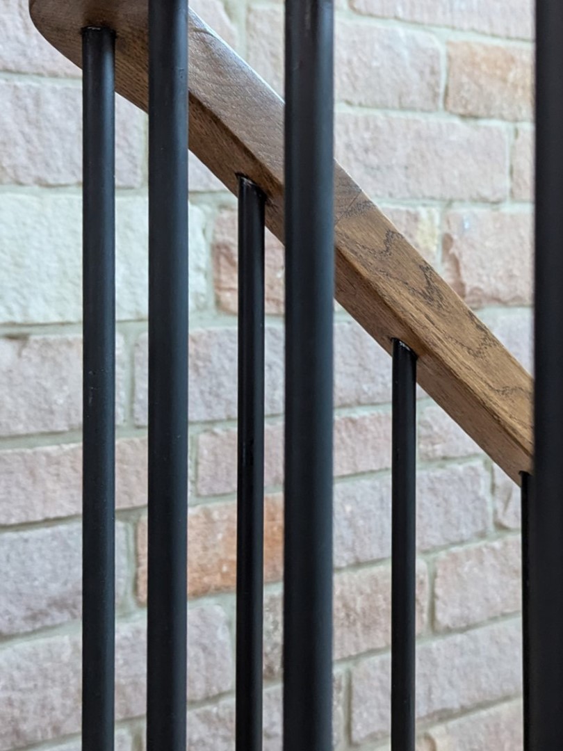 detail of timber handrail and metal balustrade at Cloud Wood End Barn with exposed stone internal wall behind