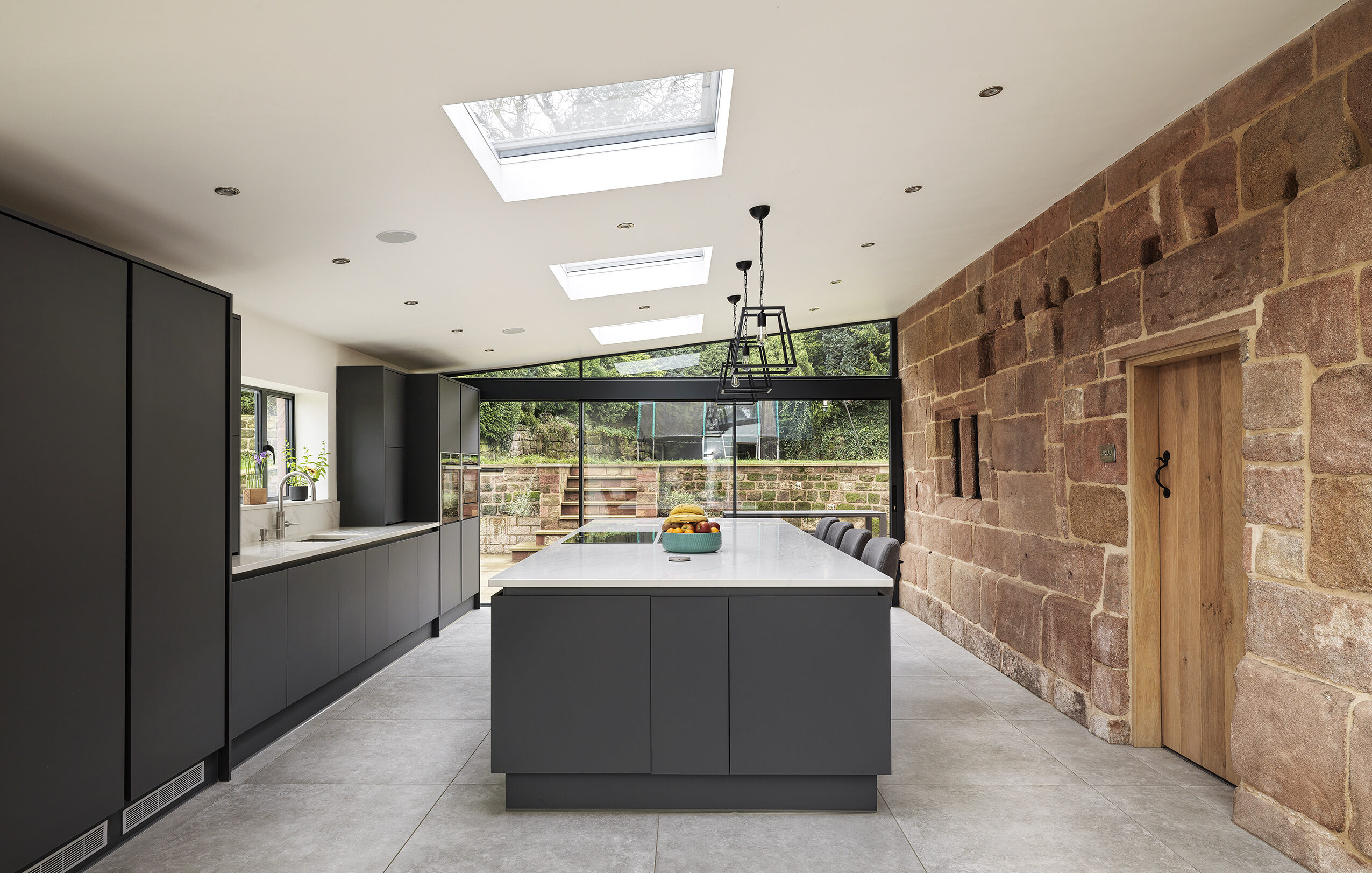 A new rear kitchen and dining extension to a Grade 2 listed farmhouse with single pitch ceiling with rooflights. Exposed original stonework with openings and mullion frames retained.