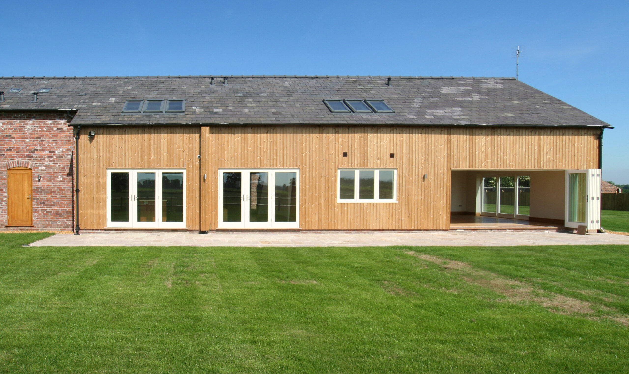 vertical timber cladding and rooflights to a barn conversion with large openings and bi-folding doors creating a large openable area