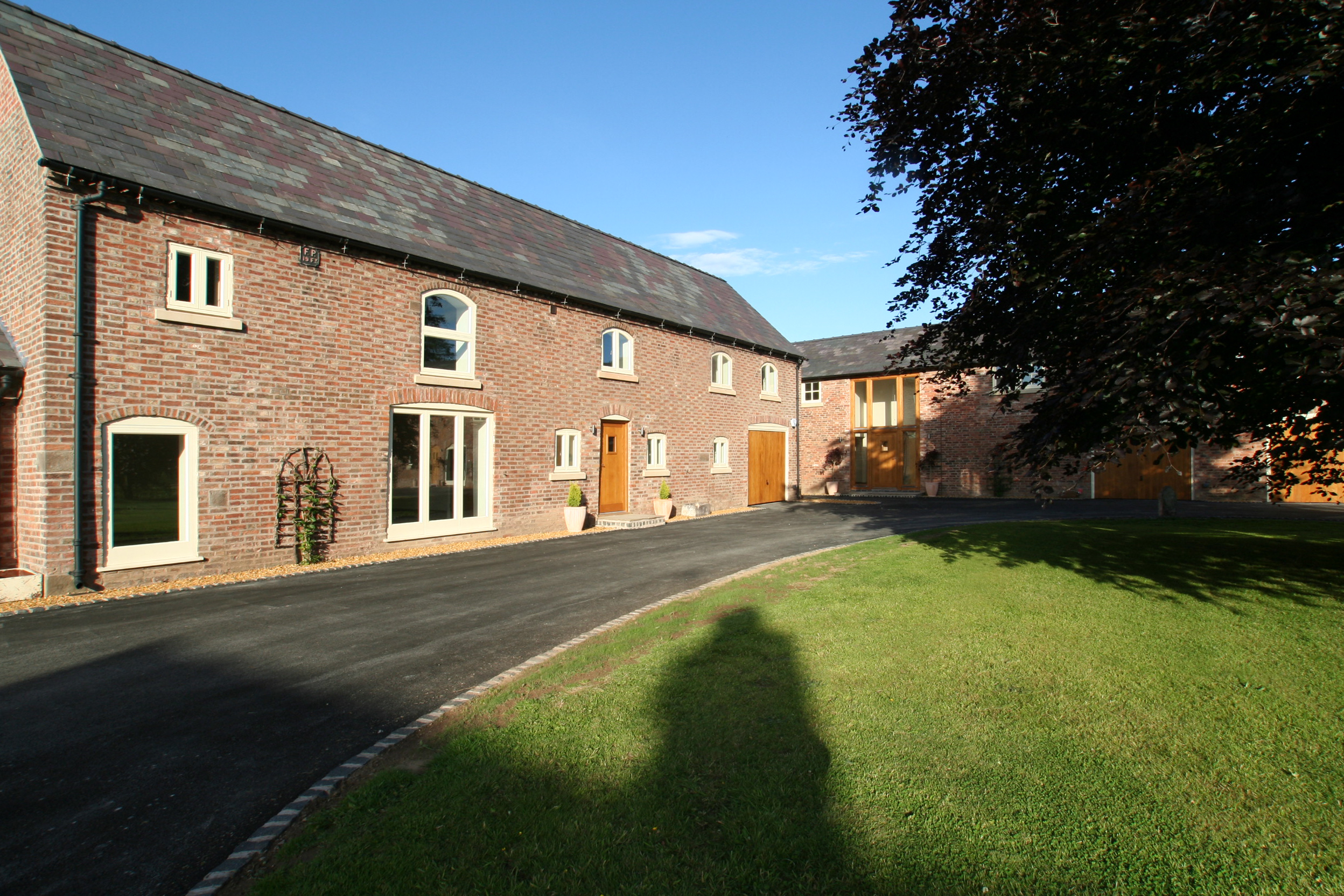 courtyard at Poole Farm with brick barn conversions with original openings retained and landscaped site providing access