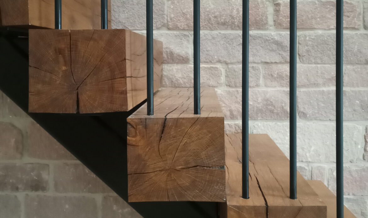A oak tread staircase with single steel structure beneath, steel balustrade with timber handrail, calling reference from agricultural buildings