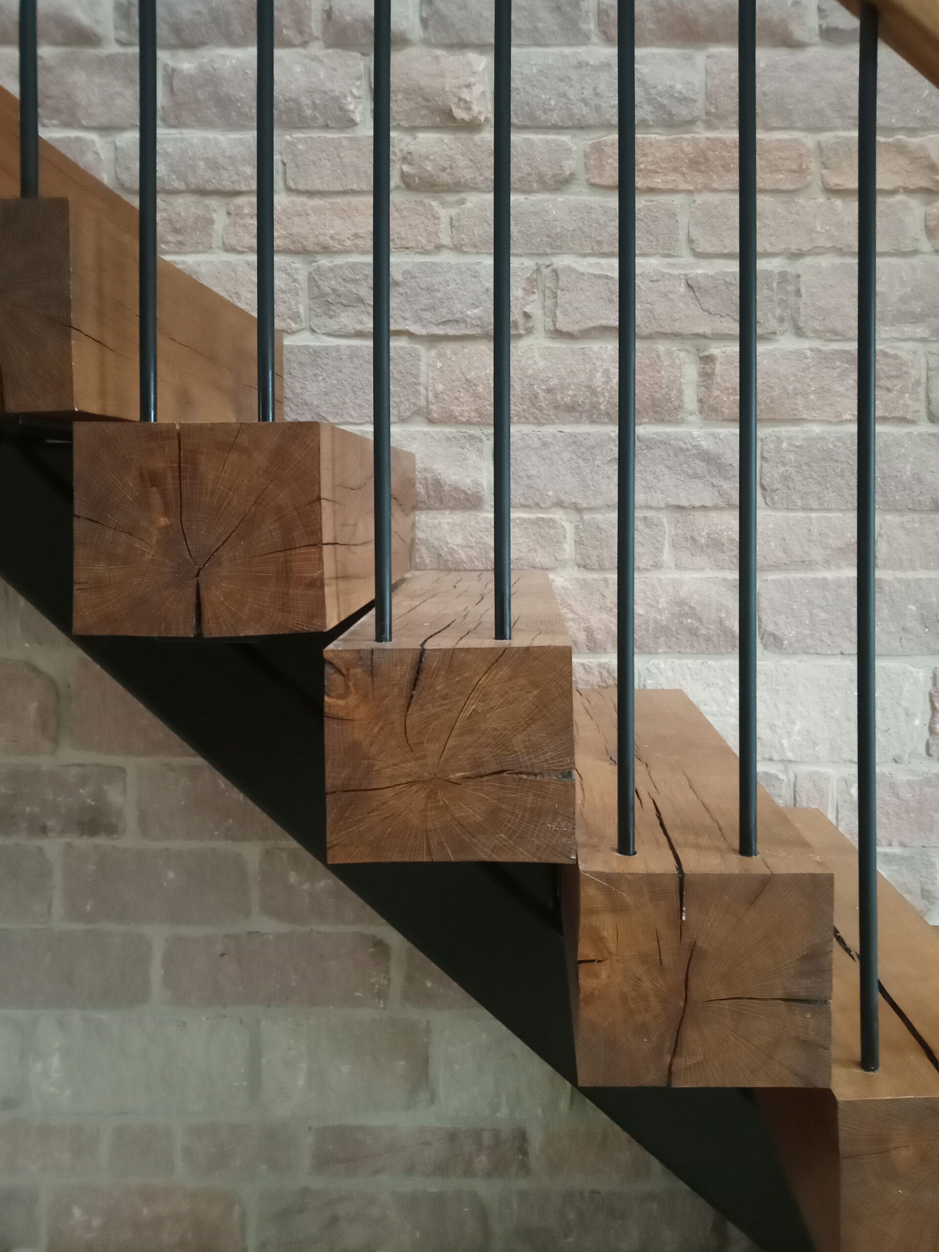 A oak tread staircase with single steel structure beneath, steel balustrade with timber handrail, calling reference from agricultural buildings