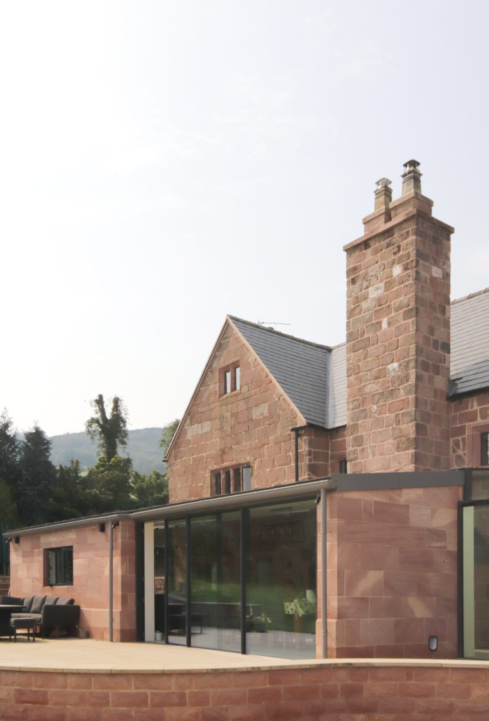 new rear extension to grade 2 listed farmhouse with coursed stone and zinc clad roof. Views of the Bosley Cloud