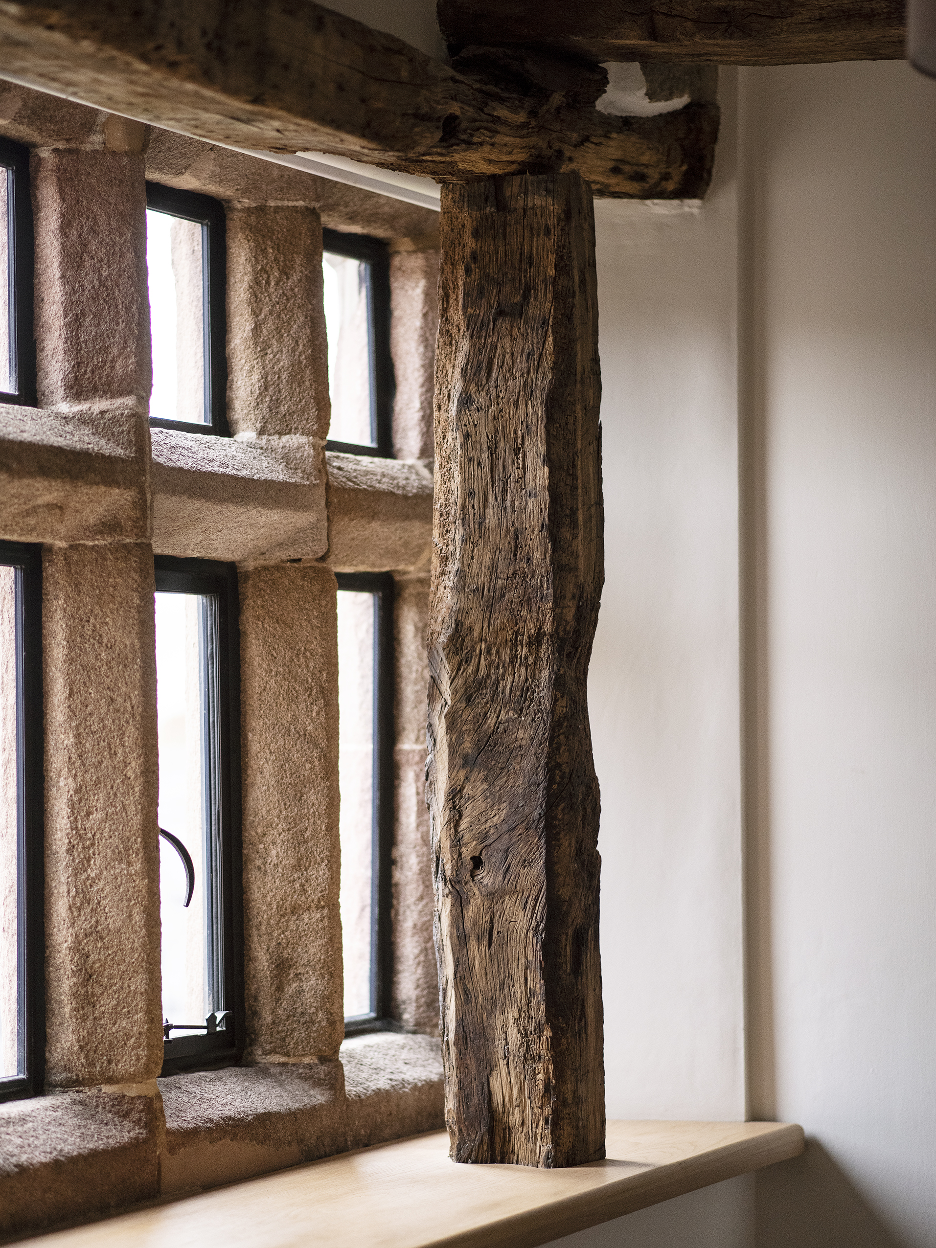 Exposed oak post and original stone mullion windows with new double glazing at a Grade 2 listed farmhouse